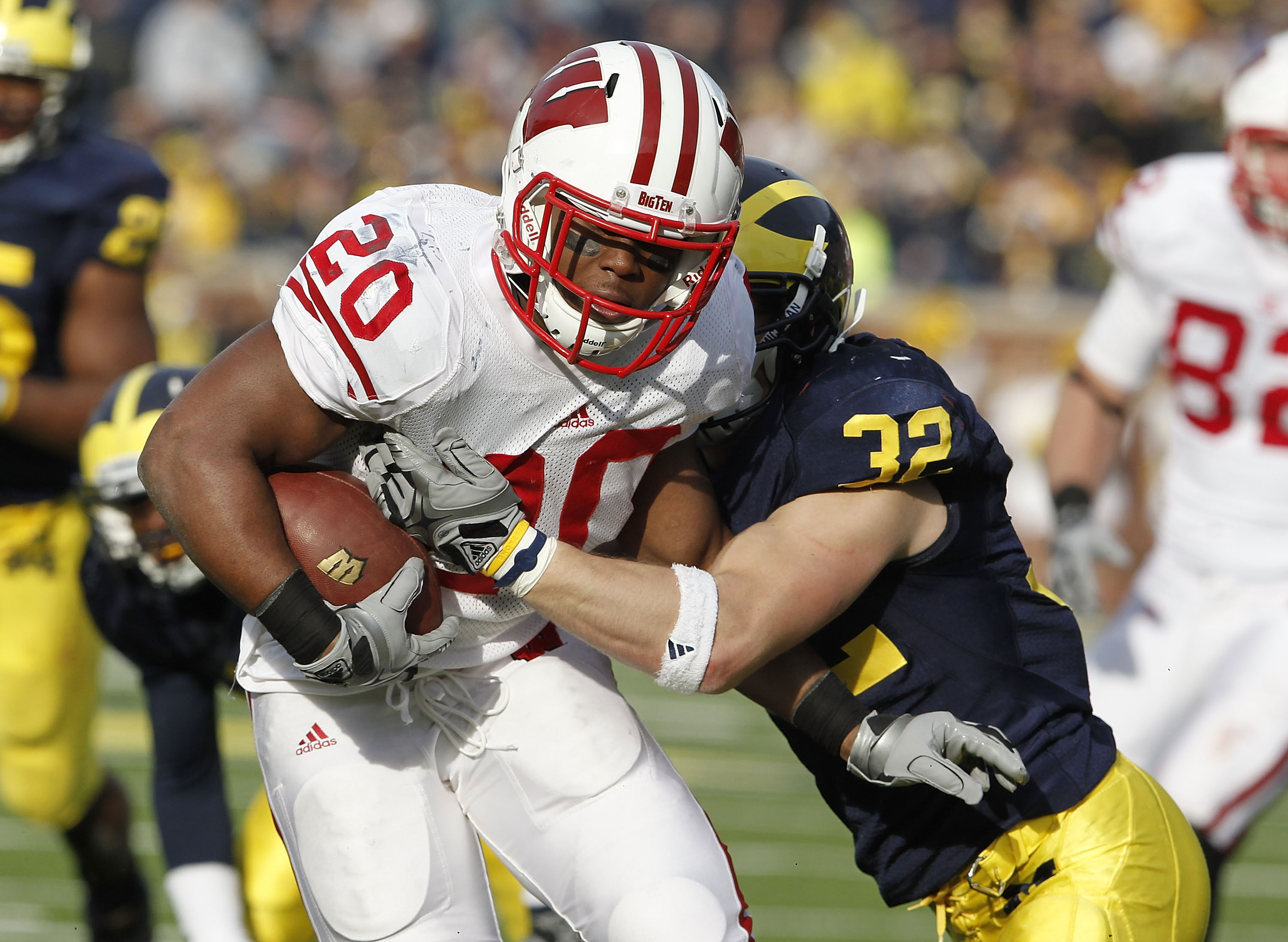 ANN ARBOR, MI - NOVEMBER 20:  James White #20 of the Wisconsin Badgers treies to get around the tackle of Jordan Kovacs #32 of the Michigan Wolverines at Michigan Stadium on November 20, 2010 in Ann Arbor, Michigan. Wisconson won the game 48-28.  (Photo b