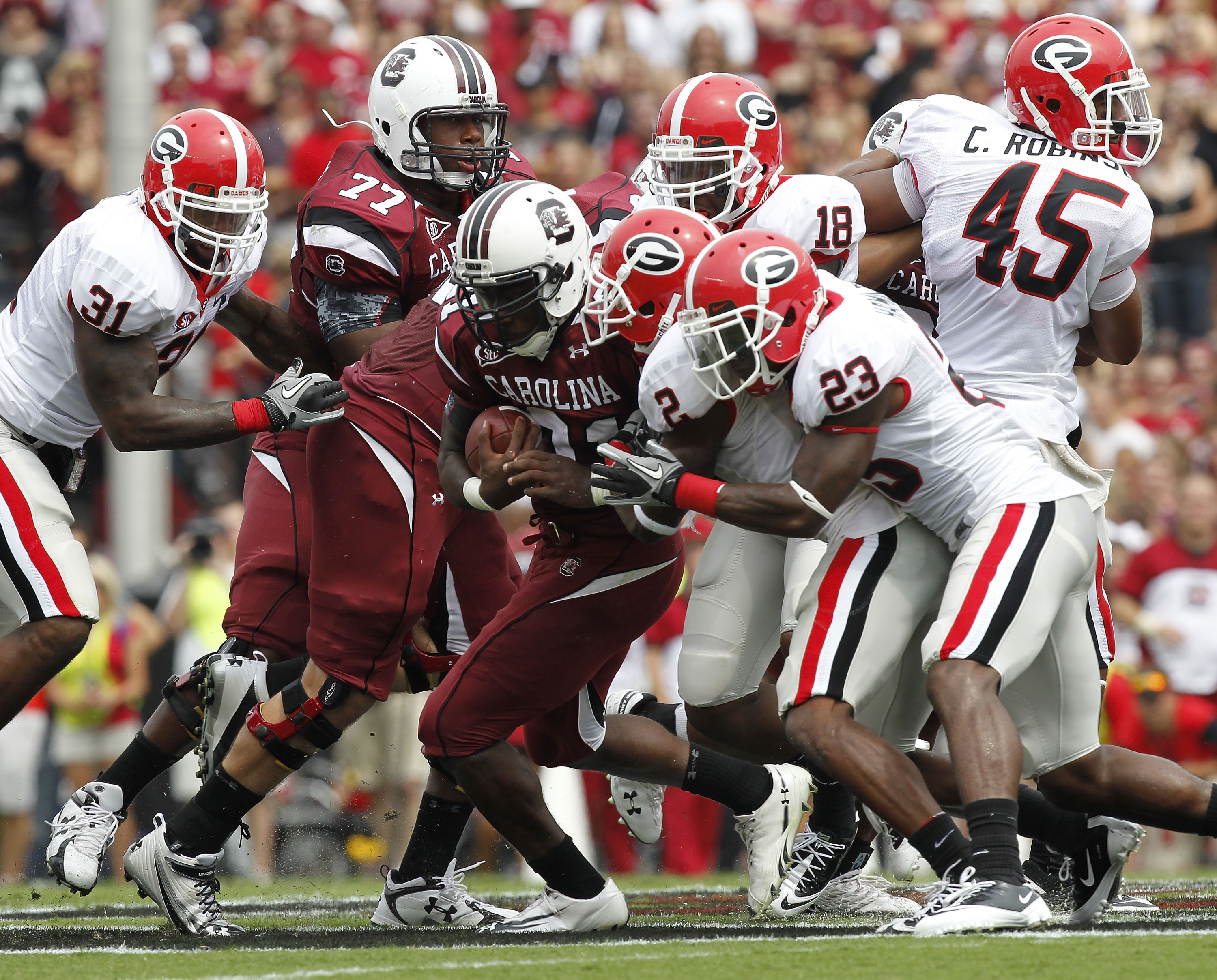 COLUMBIA, SC - SEPTEMBER 11: Tailback Marcus Lattimore #21 of the South Carolina Gamecocks (center with ball) is tackled by cornerback Brandon Boykin #2 and free safety Jakar Hamilton #23 of the Georgia Bulldogs during the game at Williams-Brice Stadium o