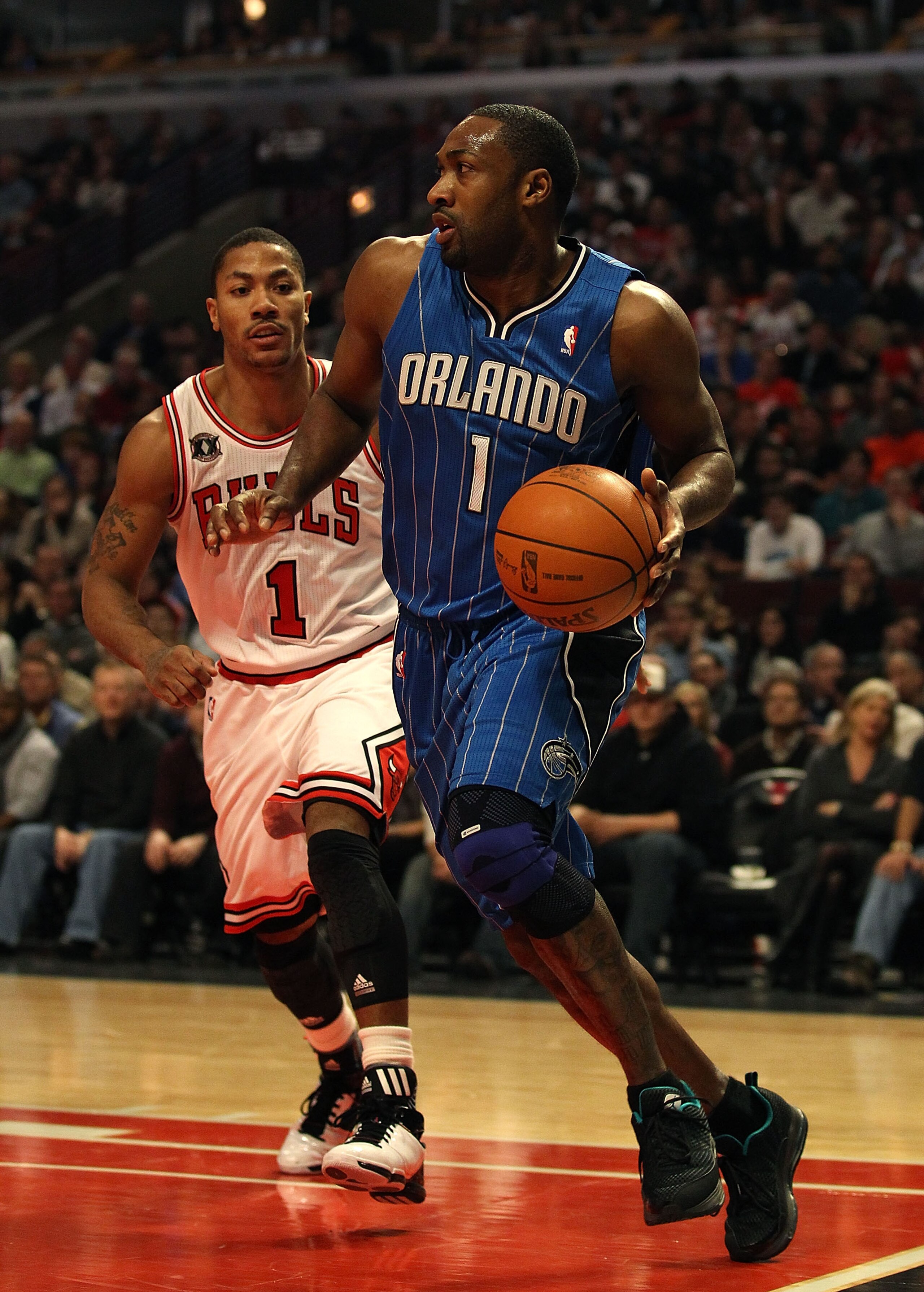 CHICAGO, IL - JANUARY 28: Gilbert Arenas #1 of the Orlando Magic moves past Derrick Rose #1 of the Chicago Bulls at the United Center on January 28, 2011 in Chicago, Illinois. The Bulls defeated the Magic 99-90. NOTE TO USER: User expressly acknowledges a
