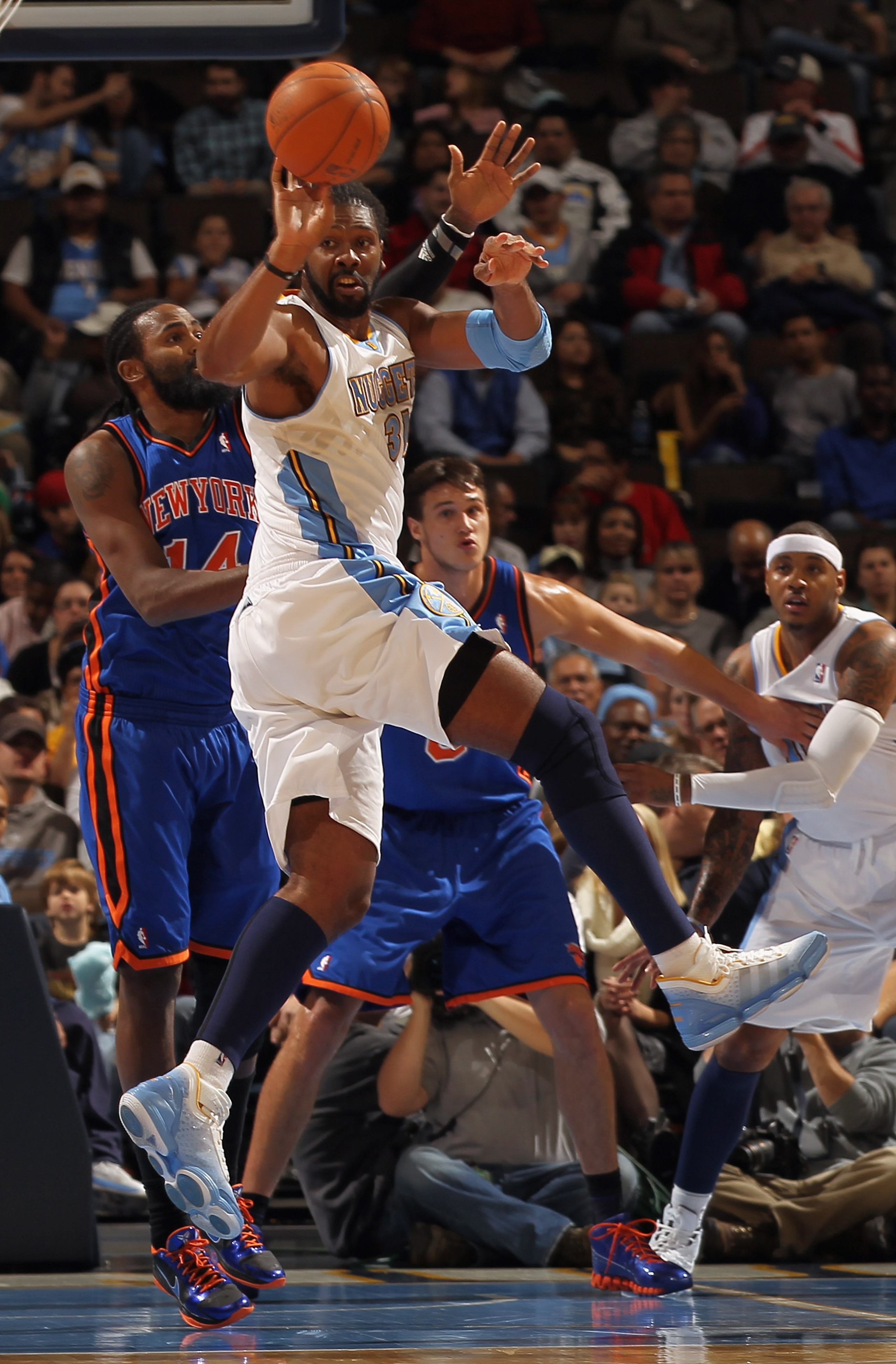 DENVER - NOVEMBER 16: Nene #31 of the Denver Nuggets passes the ball while under defensive pressure from Ronny Turiaf #14 of the New York Knicks at the Pepsi Center on November 16, 2010 in Denver, Colorado. NOTE TO USER: User expressly acknowledges and a DENVER - NOVEMBER 16: Nene #31 of the Denver Nuggets passes the ball while under defensive pressure from Ronny Turiaf #14 of the New York Knicks at the Pepsi Center on November 16, 2010 in Denver, Colorado. NOTE TO USER: User expressly acknowledges and a