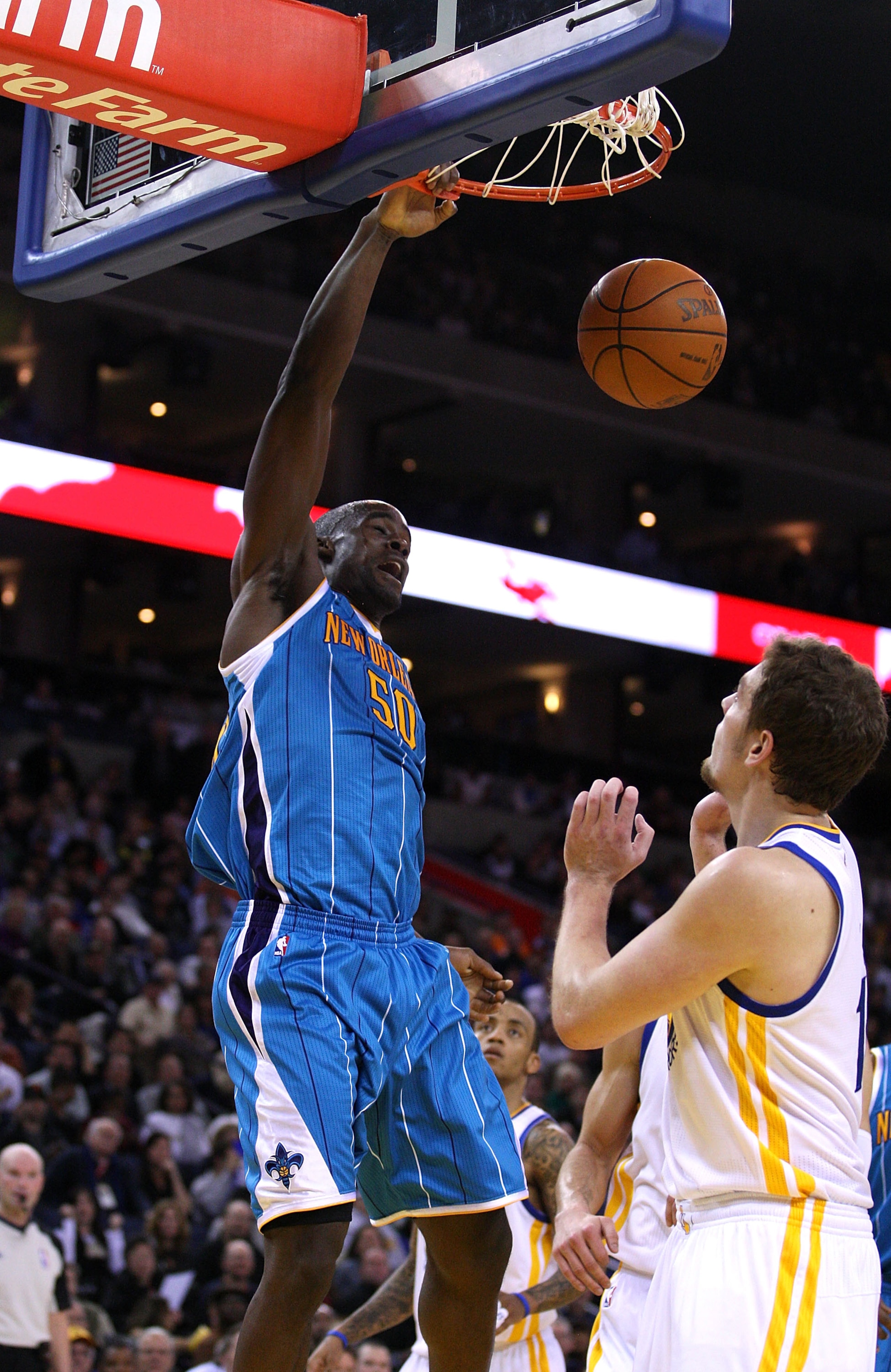 OAKLAND, CA - JANUARY 26:  Emeka Okafor #50 of the New Orleans Hornets dunks the ball over David Lee #10 of the Golden State Warriors at Oracle Arena on January 26, 2011 in Oakland, California.  NOTE TO USER: User expressly acknowledges and agrees that, b