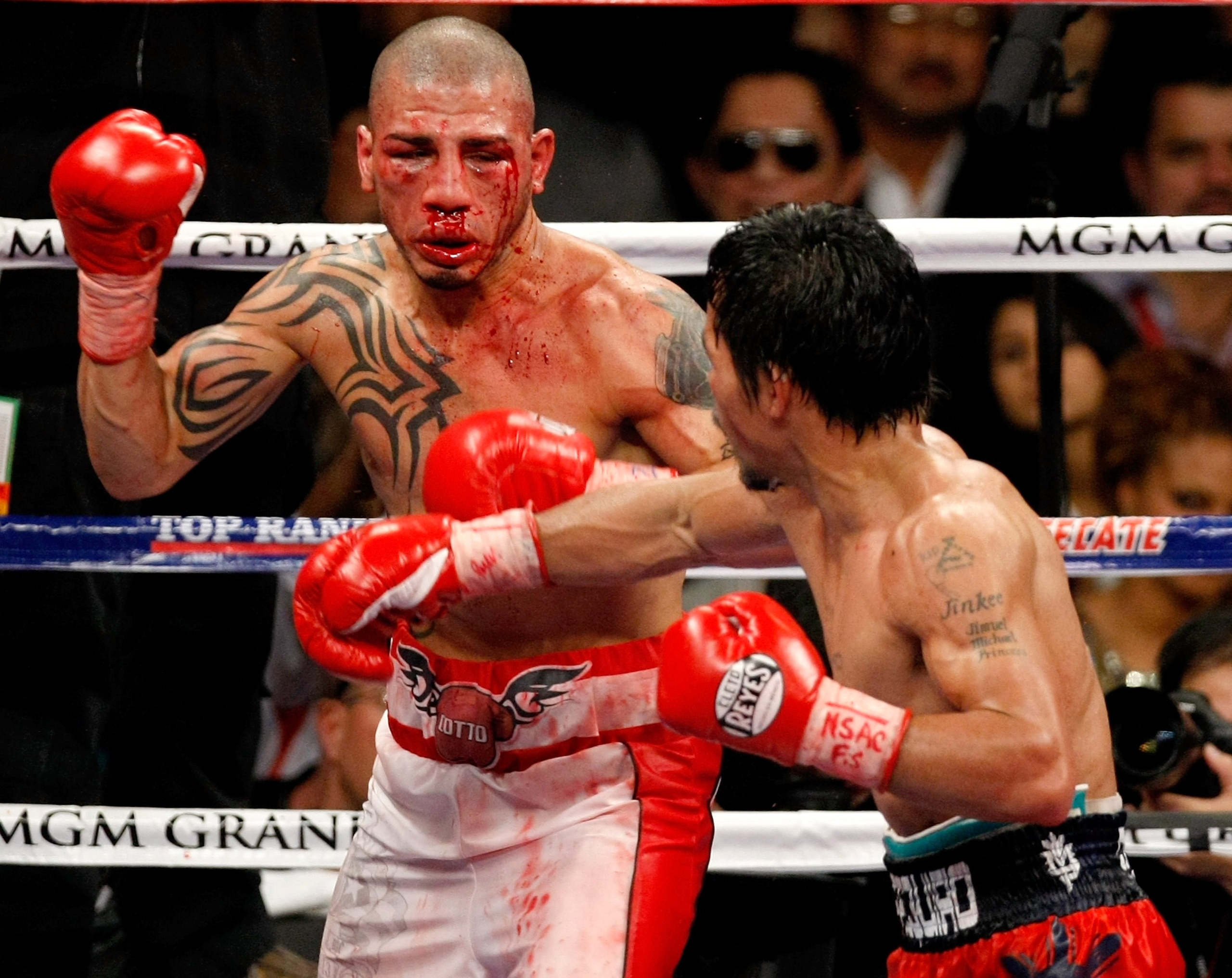 LAS VEGAS - NOVEMBER 14:  A bloodied Miguel Cotto (L) and Manny Pacquiao battle during the 11th round of their WBO welterweight title fight at the MGM Grand Garden Arena on November 14, 2009 in Las Vegas, Nevada. Pacquiao defeated Cotto by TKO in the 12th