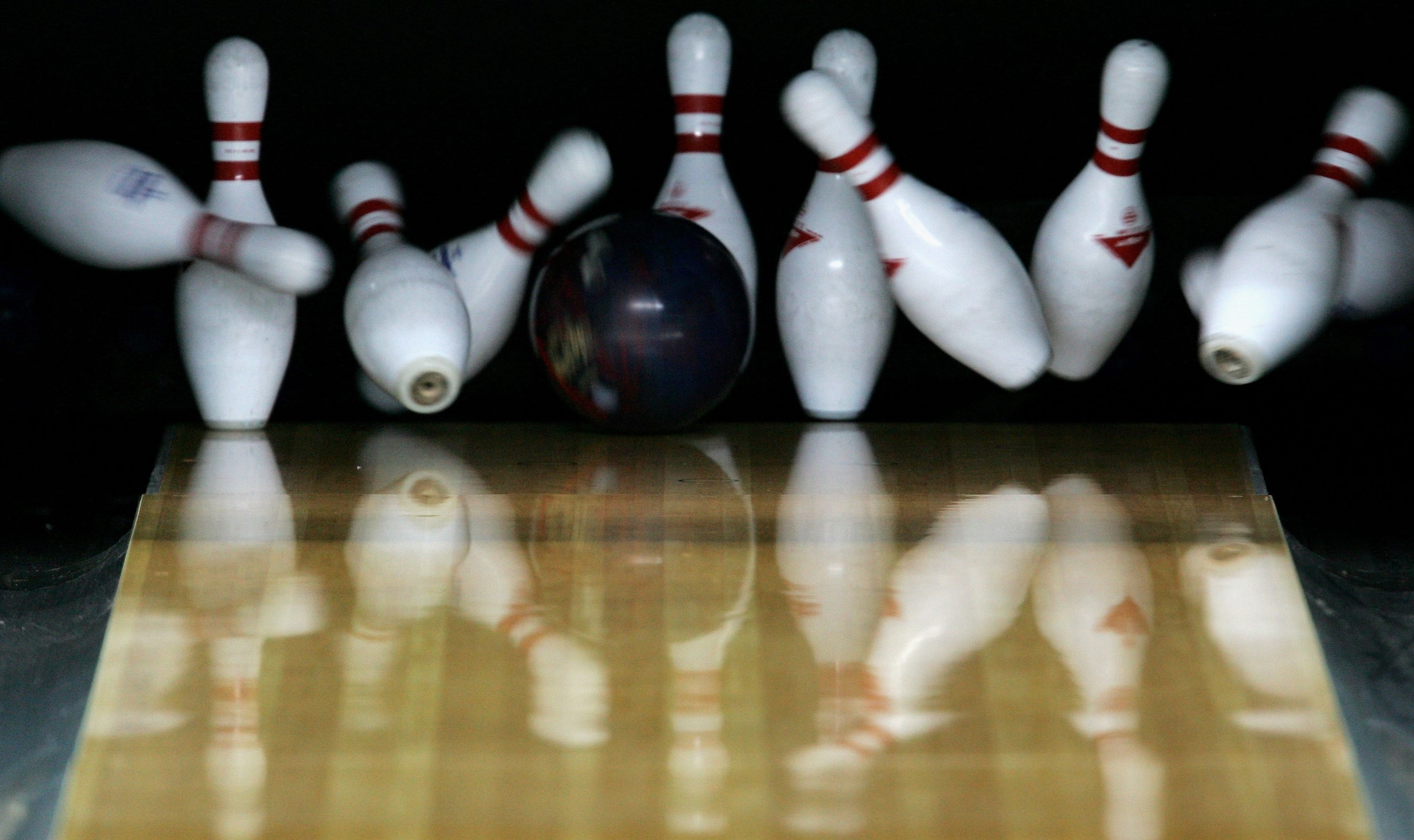 DOHA, QATAR - DECEMBER 05: A competitor clears the pins to score a strike during the Men's Trios 3 games - Squad B - 1st Block Bowling Competition at the Qatar Bowling Centre during the 15th Asian Games Doha 2006 on December 5, 2006 in Doha, Qatar. (Pho DOHA, QATAR - DECEMBER 05: A competitor clears the pins to score a strike during the Men's Trios 3 games - Squad B - 1st Block Bowling Competition at the Qatar Bowling Centre during the 15th Asian Games Doha 2006 on December 5, 2006 in Doha, Qatar. (Pho
