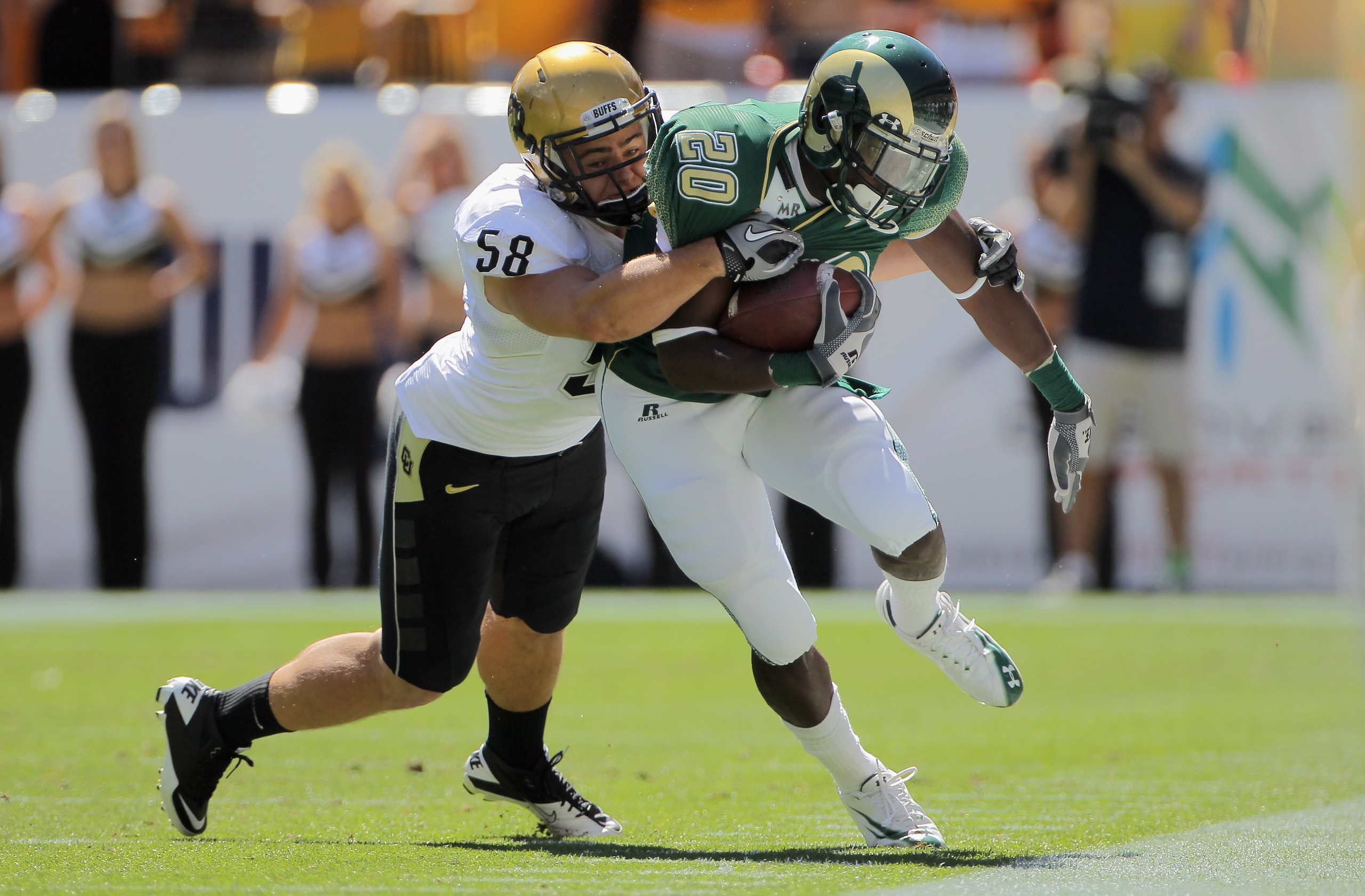 DENVER - SEPTEMBER 04:  Running back Raymond Carter #20 of the Colorado State Rams makes a pass reception and is stopped by linebacker Tyler Ahles #58 of the Colorado Buffaloes during the the Rocky Mountain Showdown at INVESCO Field at Mile High on Septem