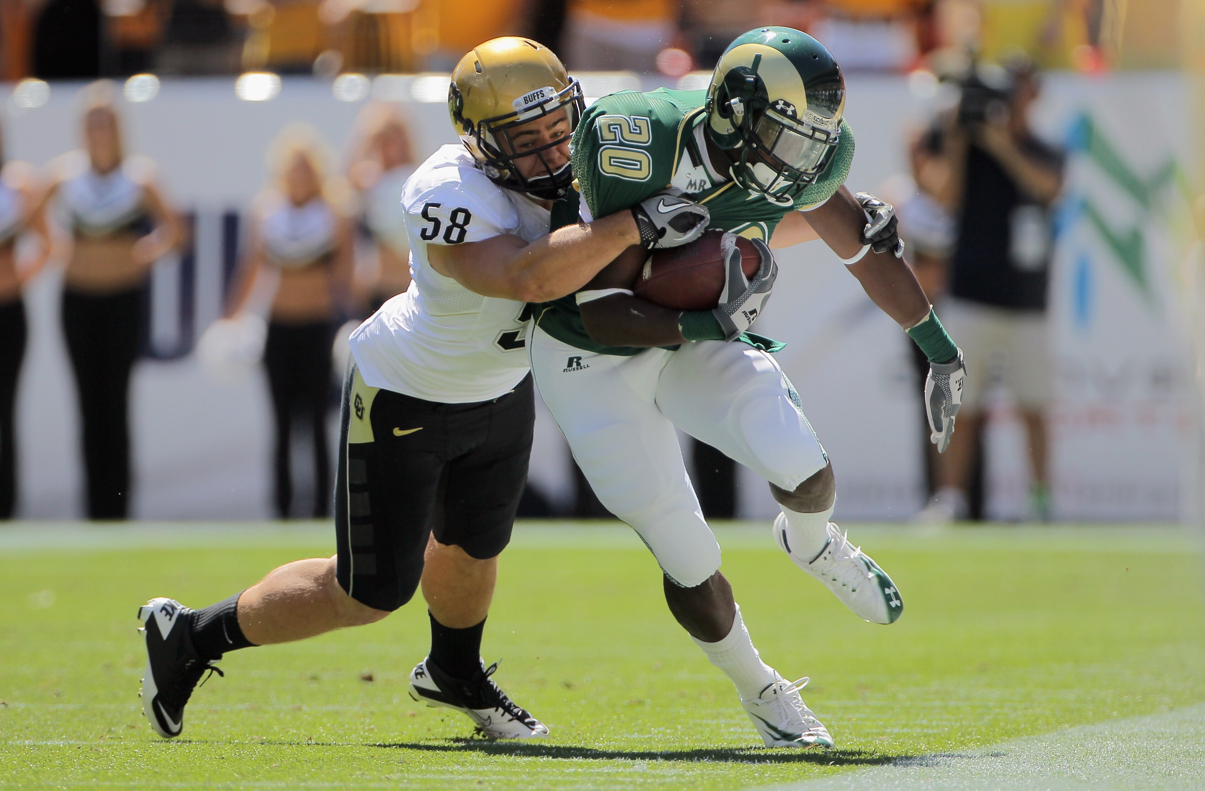DENVER - SEPTEMBER 04:  Running back Raymond Carter #20 of the Colorado State Rams makes a pass reception and is stopped by linebacker Tyler Ahles #58 of the Colorado Buffaloes during the the Rocky Mountain Showdown at INVESCO Field at Mile High on Septem