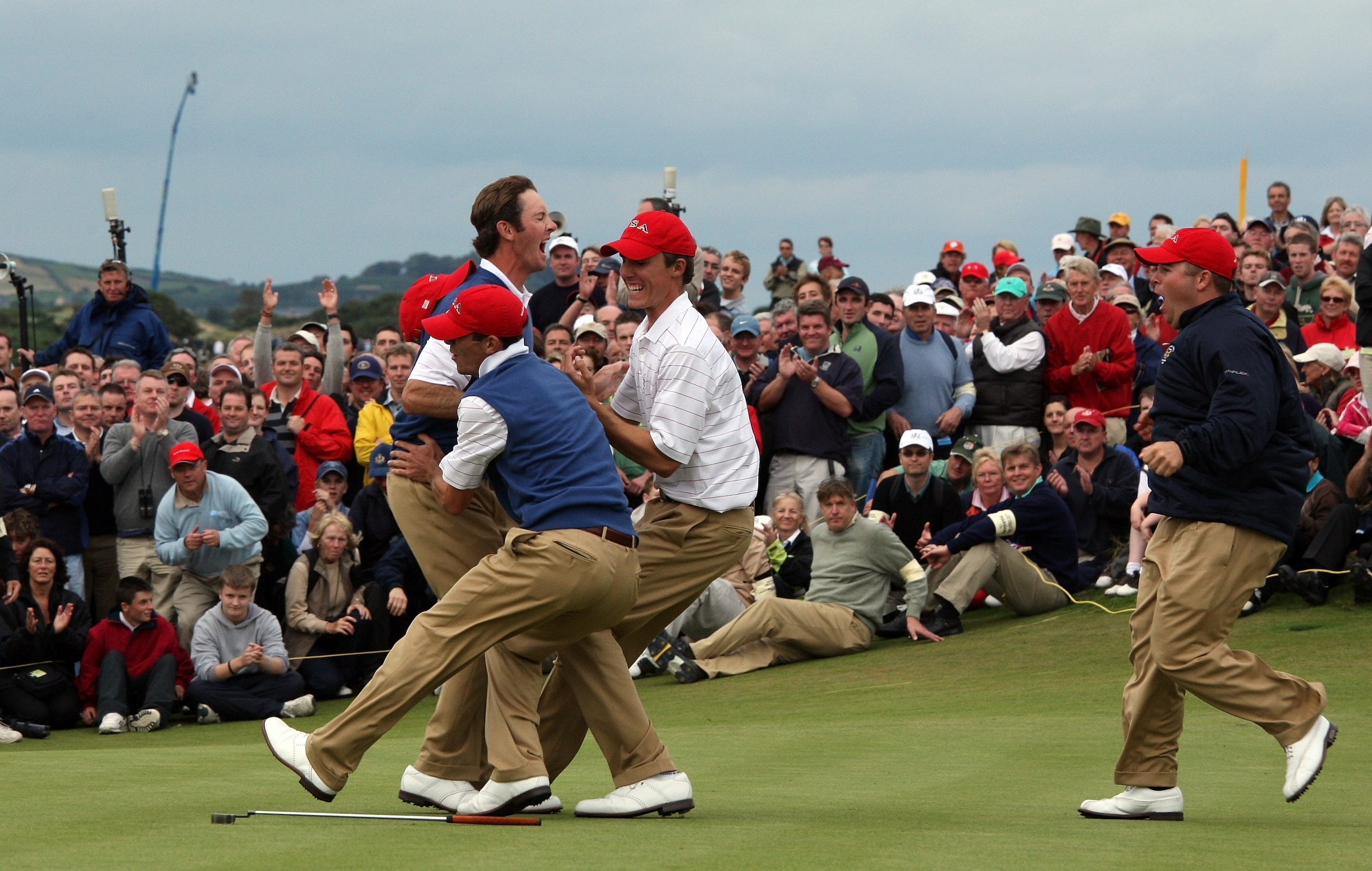 NEWCASTLE, UNITED KINGDOM - SEPTEMBER 09:  Jonathan Moore of the USA leaps into the arms of ecstatic United States team-mates as he holed a short putt for a winning eagle at the par 5, 18th hole in his afternoon singles match against Nigel Edwards of Wale