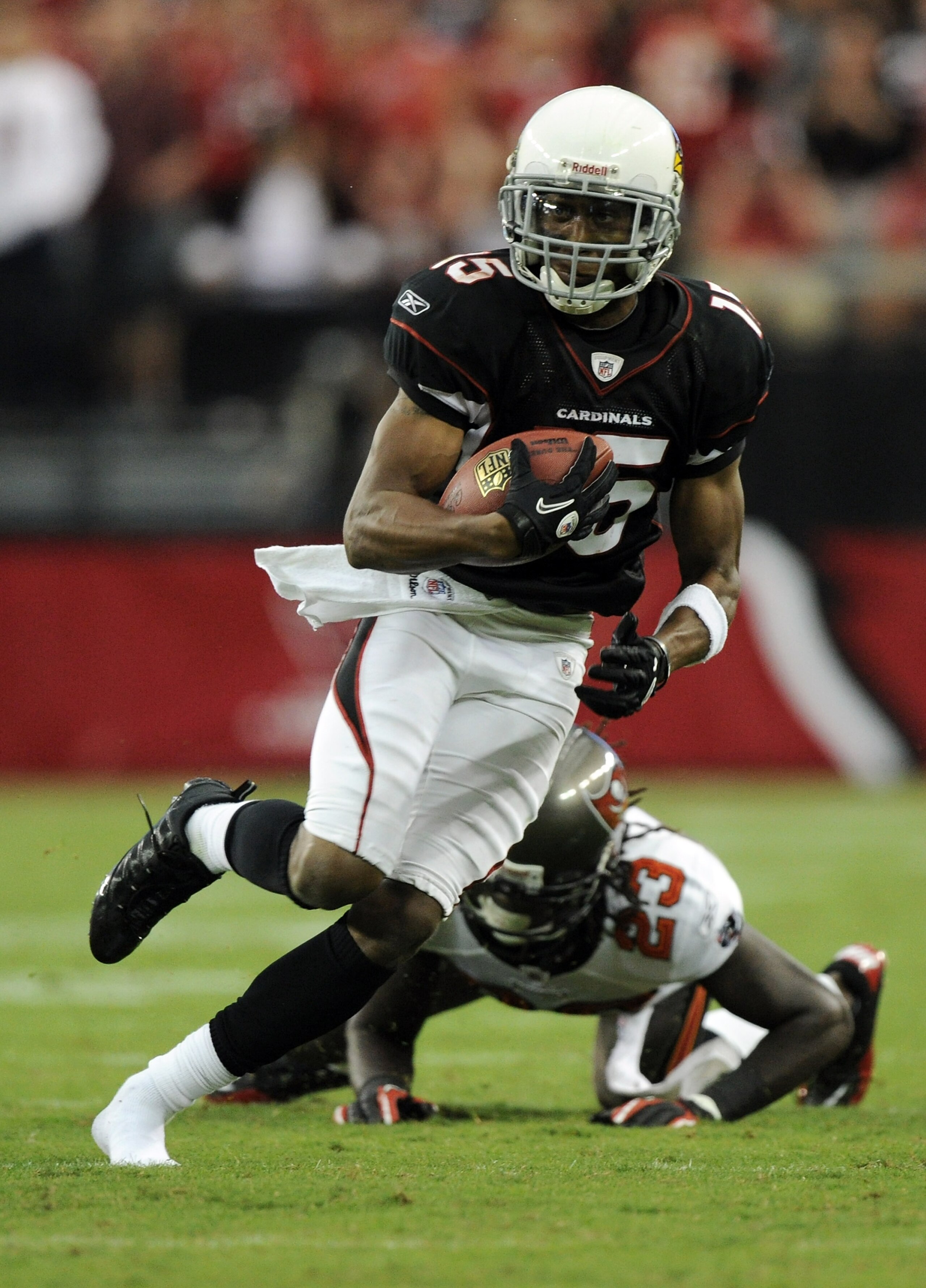 GLENDALE, AZ - OCTOBER 31:  Steve Breaston #15 of the Arizona Cardinals loses a shoe as he eludes the tackle from Myron Lewis #23 of the Tampa Bay Buccaneers during the fourth quarter at University of Phoenix Stadium on October 31, 2010 in Glendale, Arizo