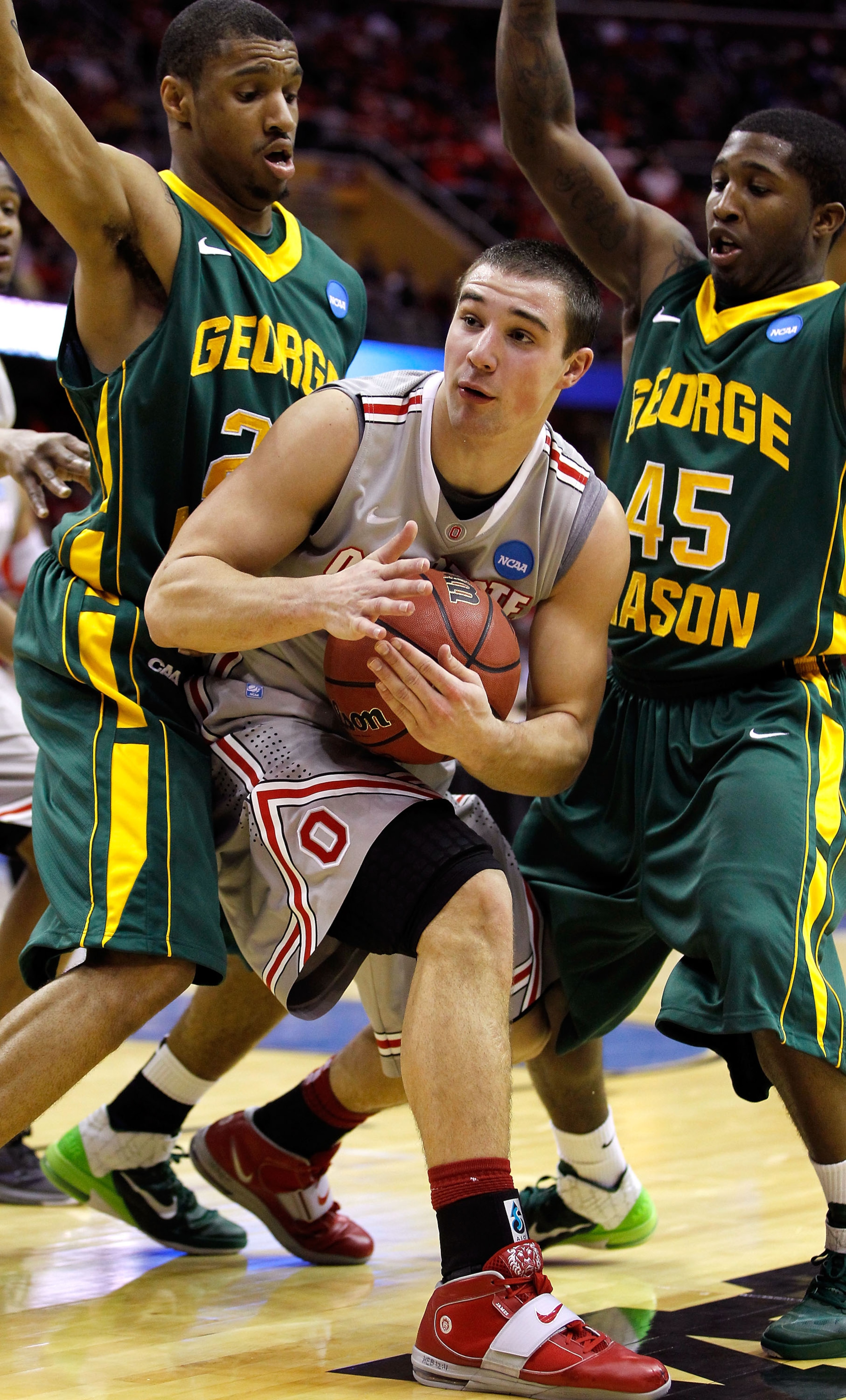 CLEVELAND, OH - MARCH 20: Aaron Craft #4 of the Ohio State Buckeyes calls a timeout while being defended by Cam Long #20 and Andre Cornelius #45 of the George Mason Patriots during the third of the 2011 NCAA men's basketball tournament at Quicken Loans A CLEVELAND, OH - MARCH 20: Aaron Craft #4 of the Ohio State Buckeyes calls a timeout while being defended by Cam Long #20 and Andre Cornelius #45 of the George Mason Patriots during the third of the 2011 NCAA men's basketball tournament at Quicken Loans A
