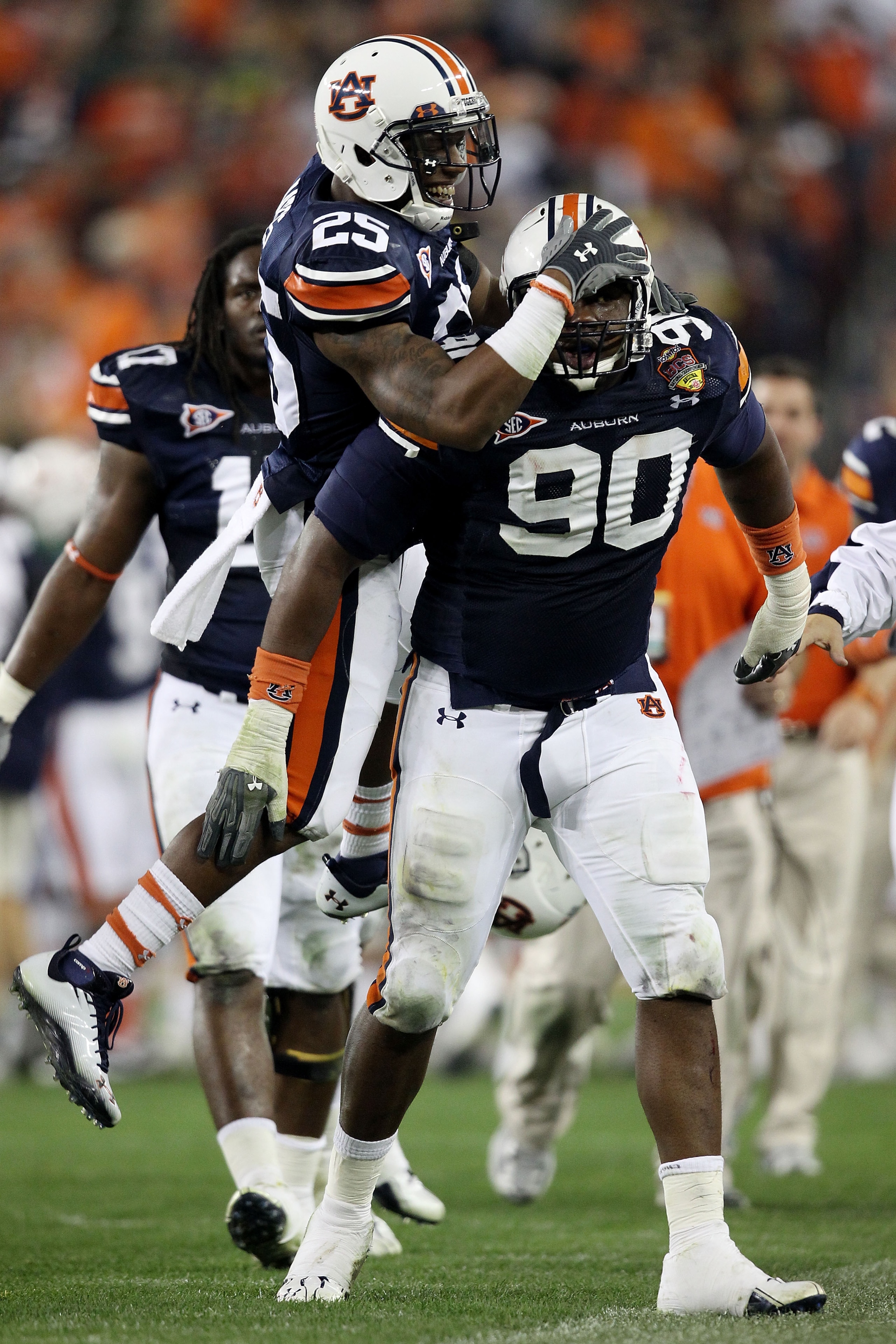 GLENDALE, AZ - JANUARY 10:  Nick Fairley #90 of the Auburn Tigers is congratulated by Daren Bates #25 on a sack against the Oregon Ducks during the Tostitos BCS National Championship Game at University of Phoenix Stadium on January 10, 2011 in Glendale, A