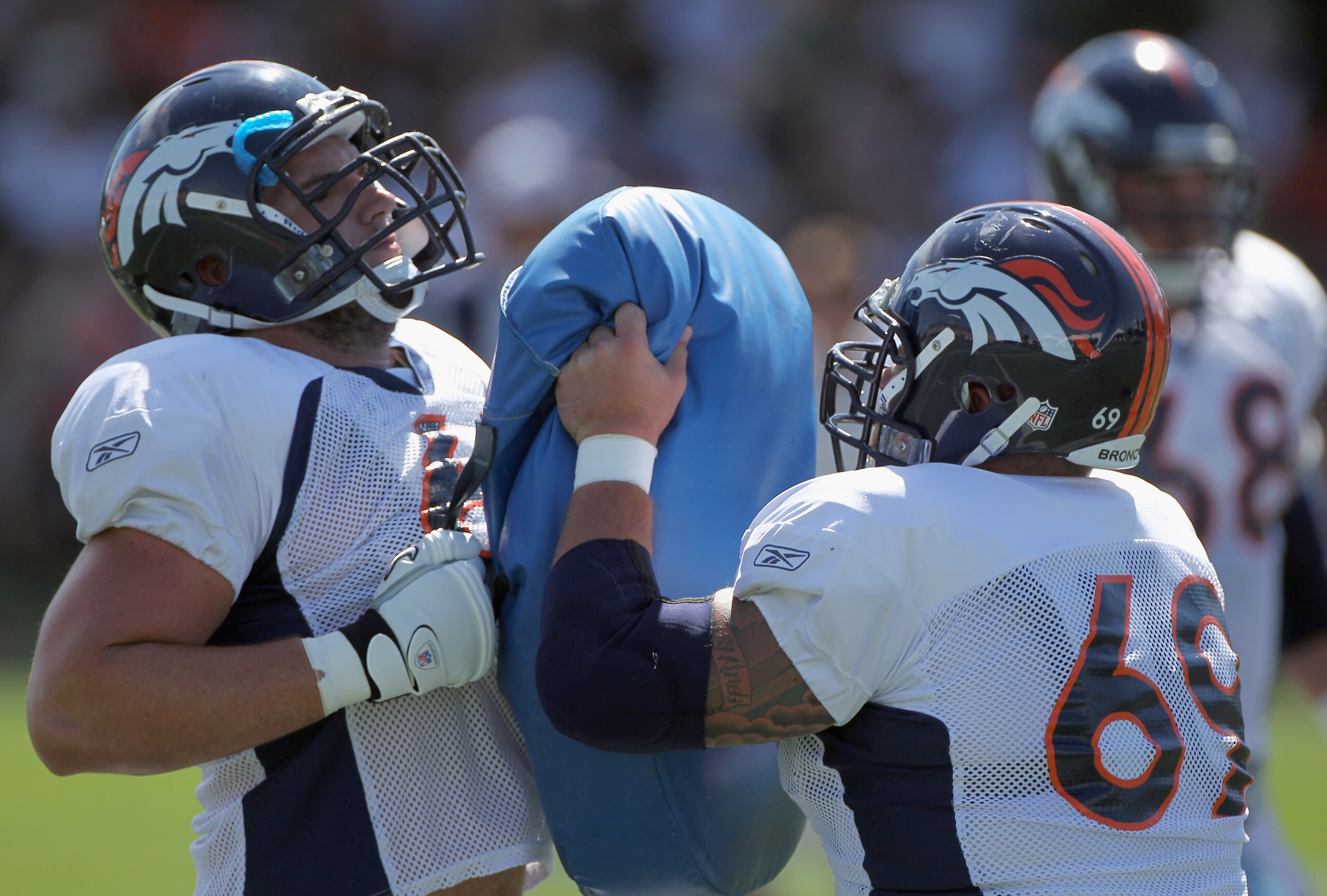 ENGLEWOOD, CO - AUGUST 18:  Offensiuve linemen Paul Duncan #61 and Eric Olsen #69 of the Denver Broncos participate in a blocking drill during training camp practice at Dove Valley on August 18, 2010 in Englewood, Colorado. The forecasted record high temp