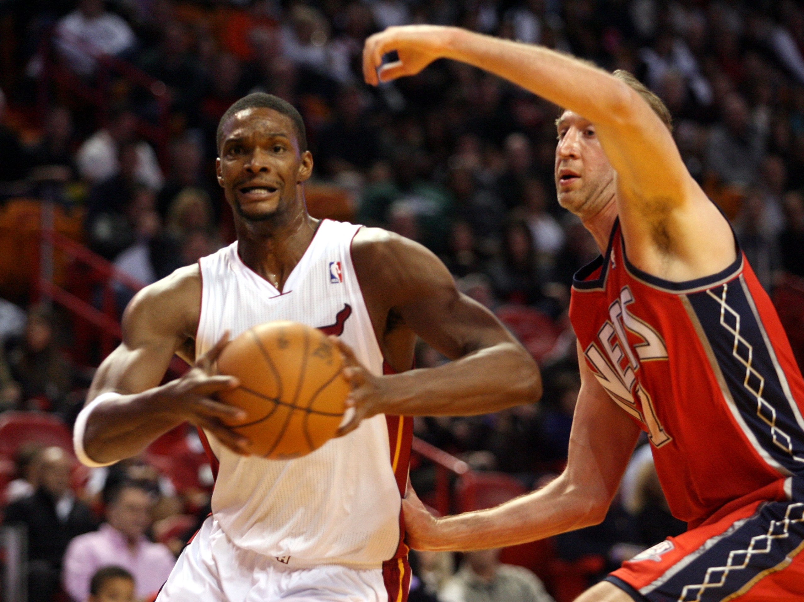 MIAMI - NOVEMBER 06:  Forward Chris Bosh #1 of the Miami Heat drives against center Troy Murphy #7 of the New Jersey Nets  at American Airlines Arena on November 6, 2010 in Miami, Florida. NOTE TO USER: User expressly acknowledges and agrees that, by down