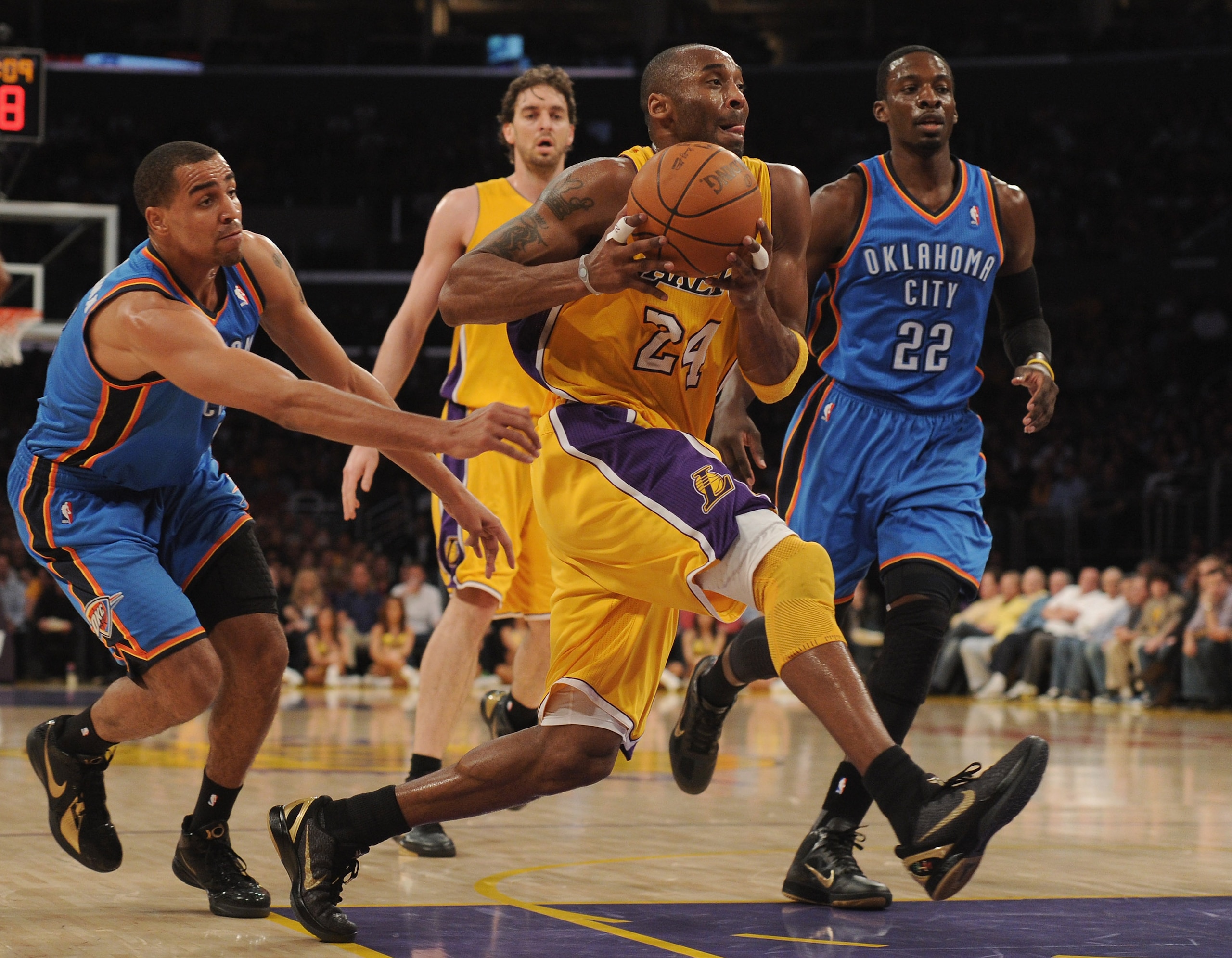 LOS ANGELES, CA - JANUARY 17:  Kobe Bryant #24 of the Los Angeles Lakers splits beats Thabo Sefolosha #2 and Jeff Green #22 of the Oklahoma City Thunder to the basket at the Staples Center on January 17, 2011 in Los Angeles, California.  (Photo by Harry H