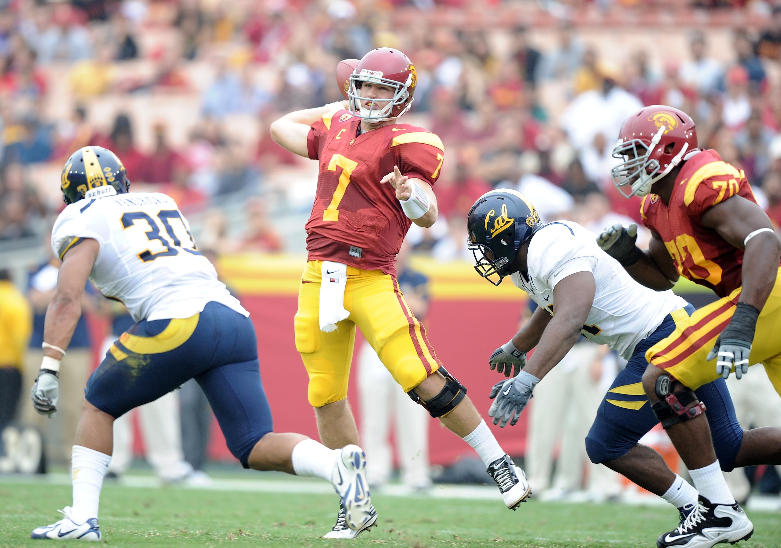 LOS ANGELES, CA - OCTOBER 16:  Matt Barkley #7 of the USC Trojans scrambles to make a pass in front of Mychal Kendricks #30 and Cameron Jordan #97 of the California Golden Bears during the first quarter at Los Angeles Memorial Coliseum on October 16, 2010