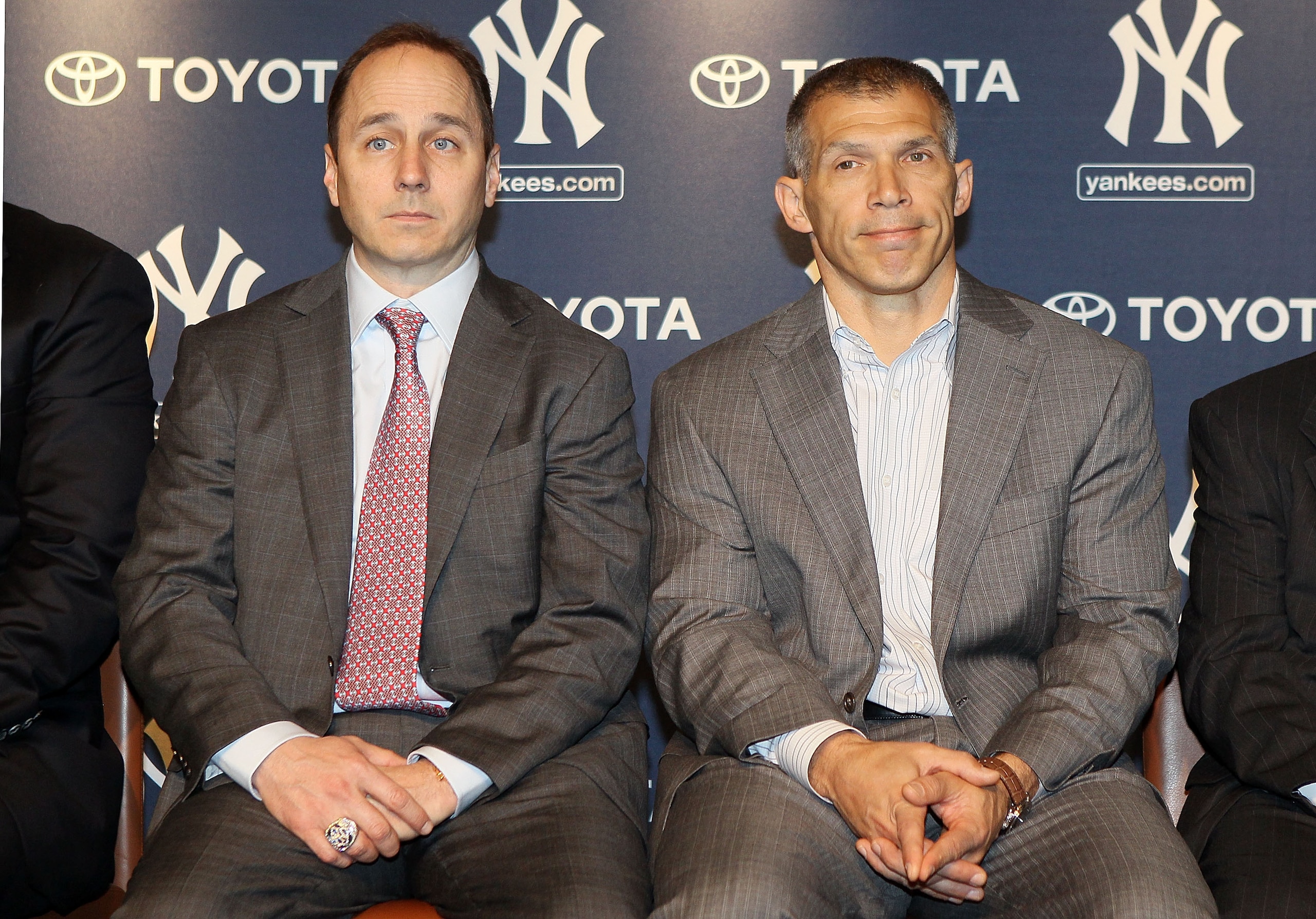 NEW YORK, NY - JANUARY 19:  General manager Brian Cashman (L) and manager Joe Girardi of the New York Yankees listen as Rafael Soriano (not pictured) speaks during his introduction press conference on January 19, 2011 at Yankee Stadium in the Bronx boroug
