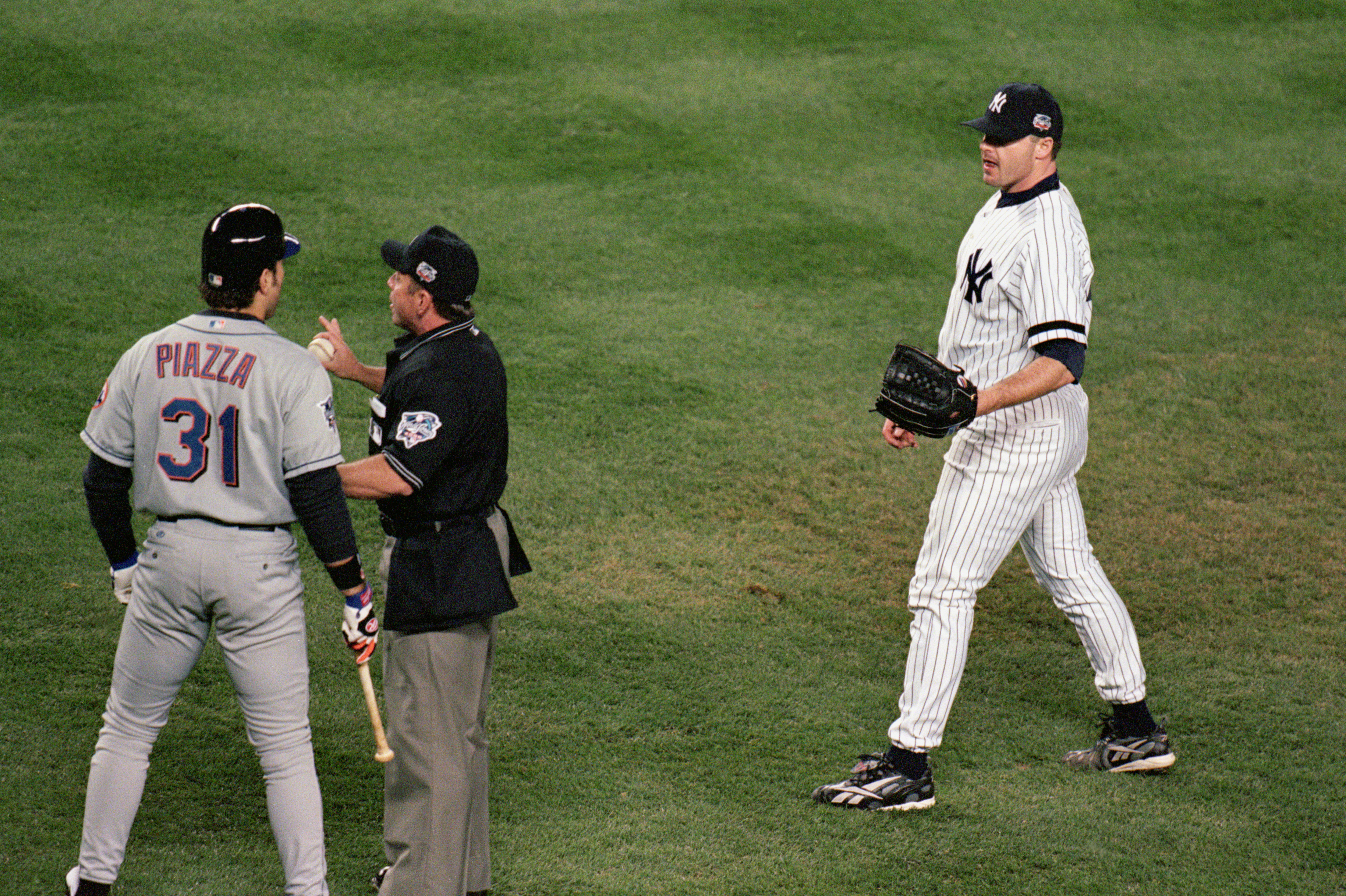 NEW YORK - OCTOBER 22:  Pitcher Roger Clemens #22 of the New York Yankees watches as Mike Piazza #31 of the New York Mets argues with the home plate umpire during game 2 of the World Series at Yankee Stadium in New York, New York on October 22, 2000.  The