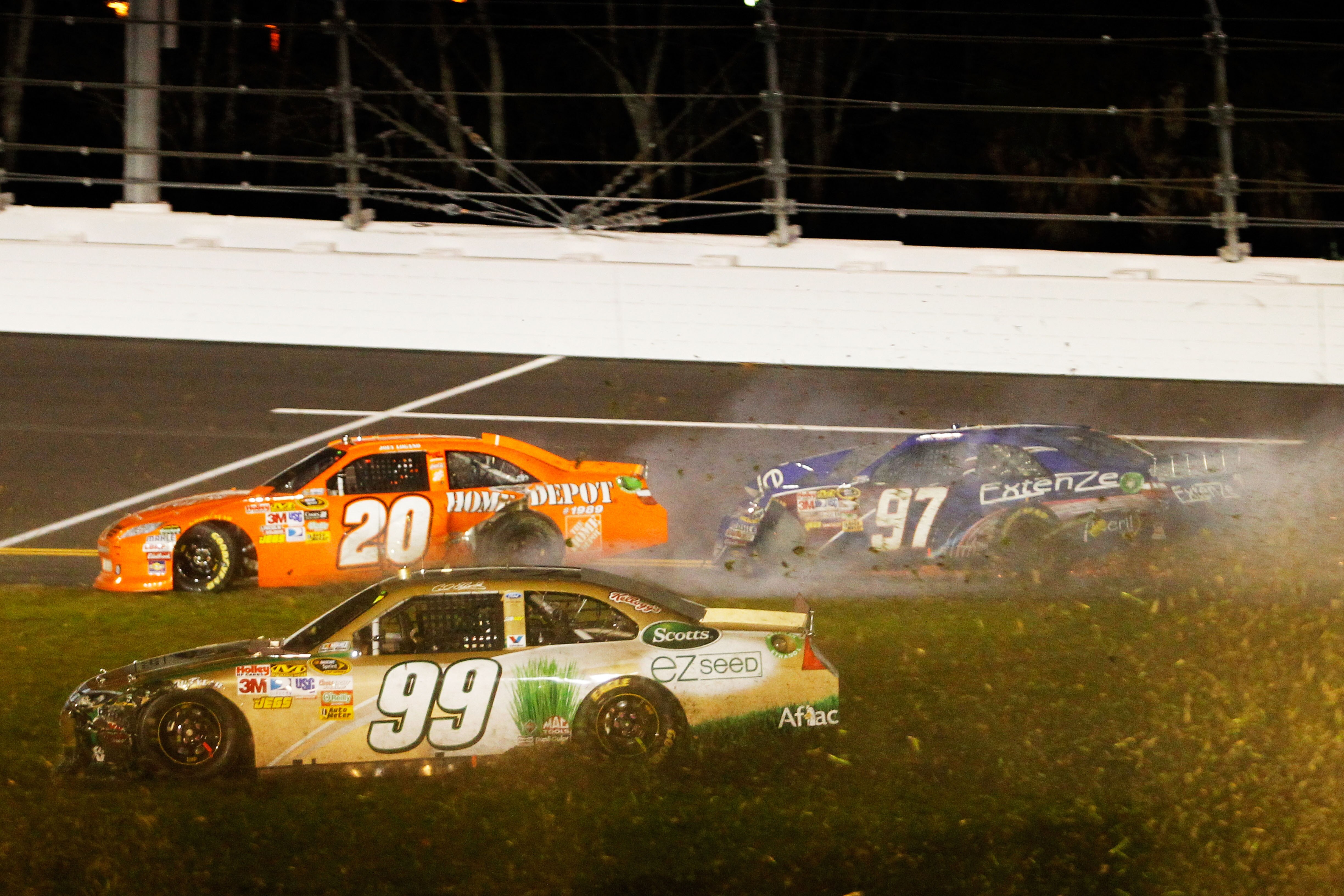 DAYTONA BEACH, FL - FEBRUARY 12:  Carl Edwards, driver of the #99 Scotts Ford, drives through the grass after crashing with Joey Logano, driver of the #20 Home Depot Toyota, and Kevin Conway, driver of the #97 ExtenZe Toyota, during the NASCAR Budweiser S