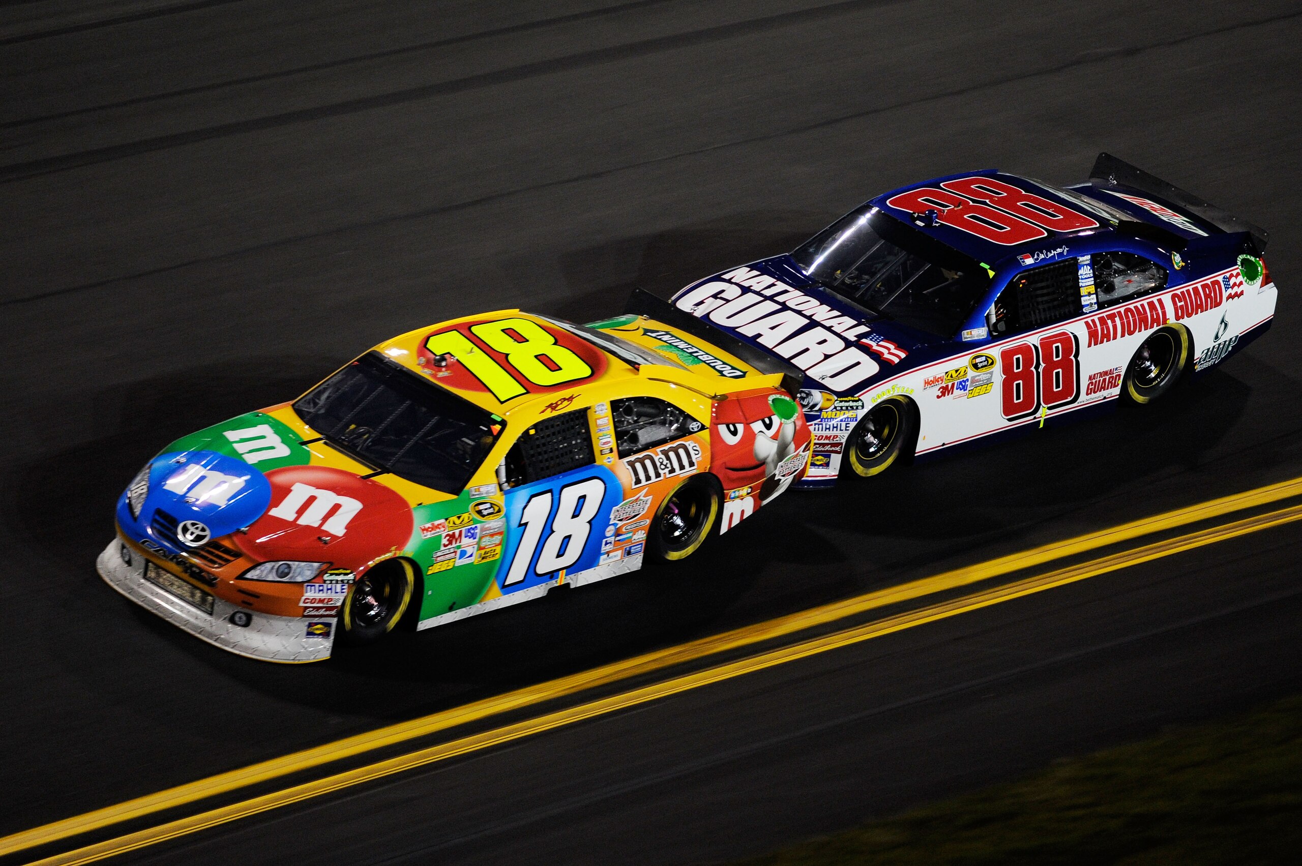 DAYTONA BEACH, FL - FEBRUARY 12:  Kyle Busch, driver of the #18 M&M's Toyota, leads Dale Earnhardt Jr., driver of the #88 National Guard/AMP Energy Chevrolet, during the NASCAR Budweiser Shootout at Daytona International Speedway on February 12, 2011 in D