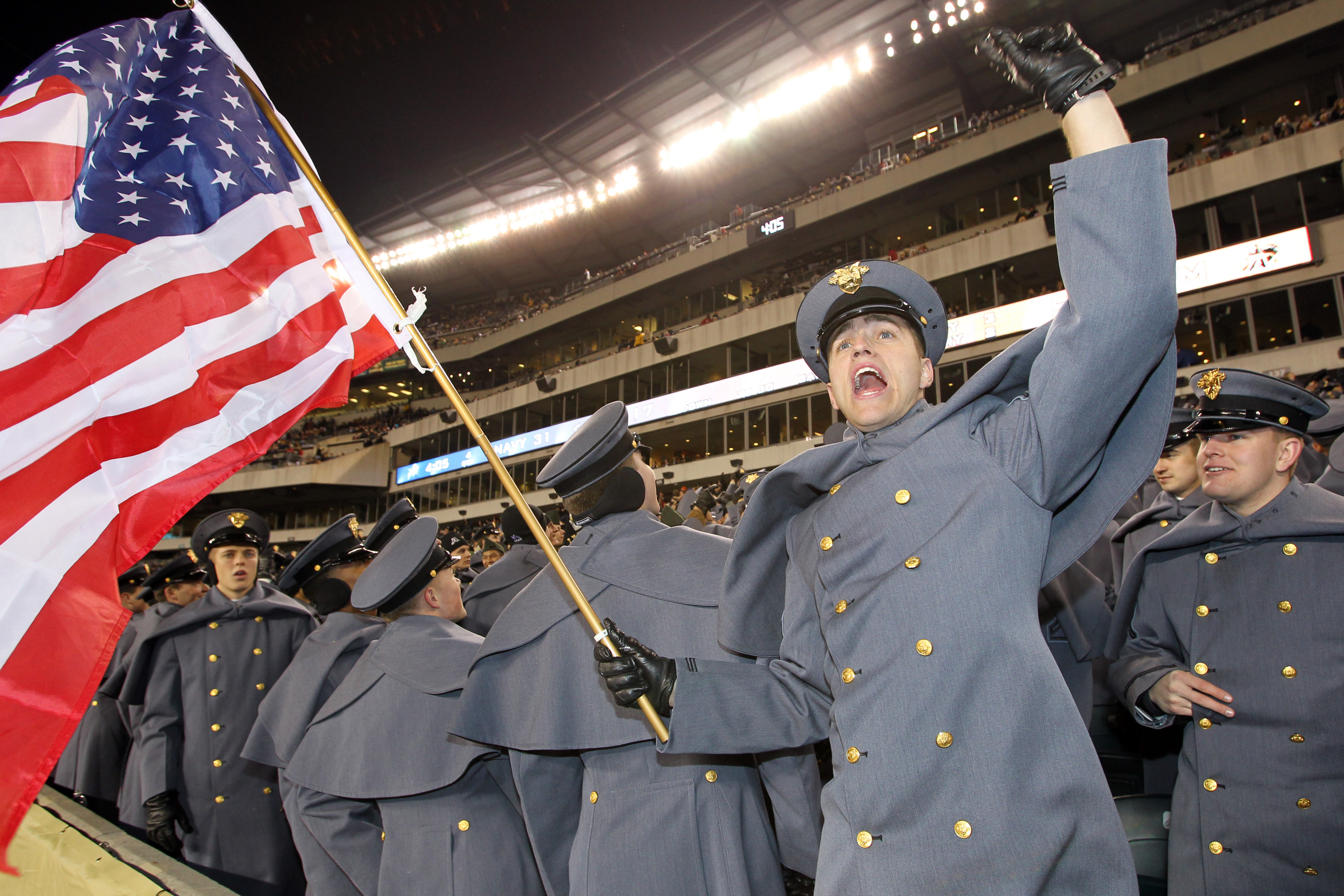 PHILADELPHIA - DECEMBER 11: An Army Cadet waves an American flag and cheers during a game between the Navy Midshipmen and the Army Black Knights on December 11, 2010 at Lincoln Financial Field in Philadelphia, Pennsylvania. The Midshipmen won 31-17. (Phot