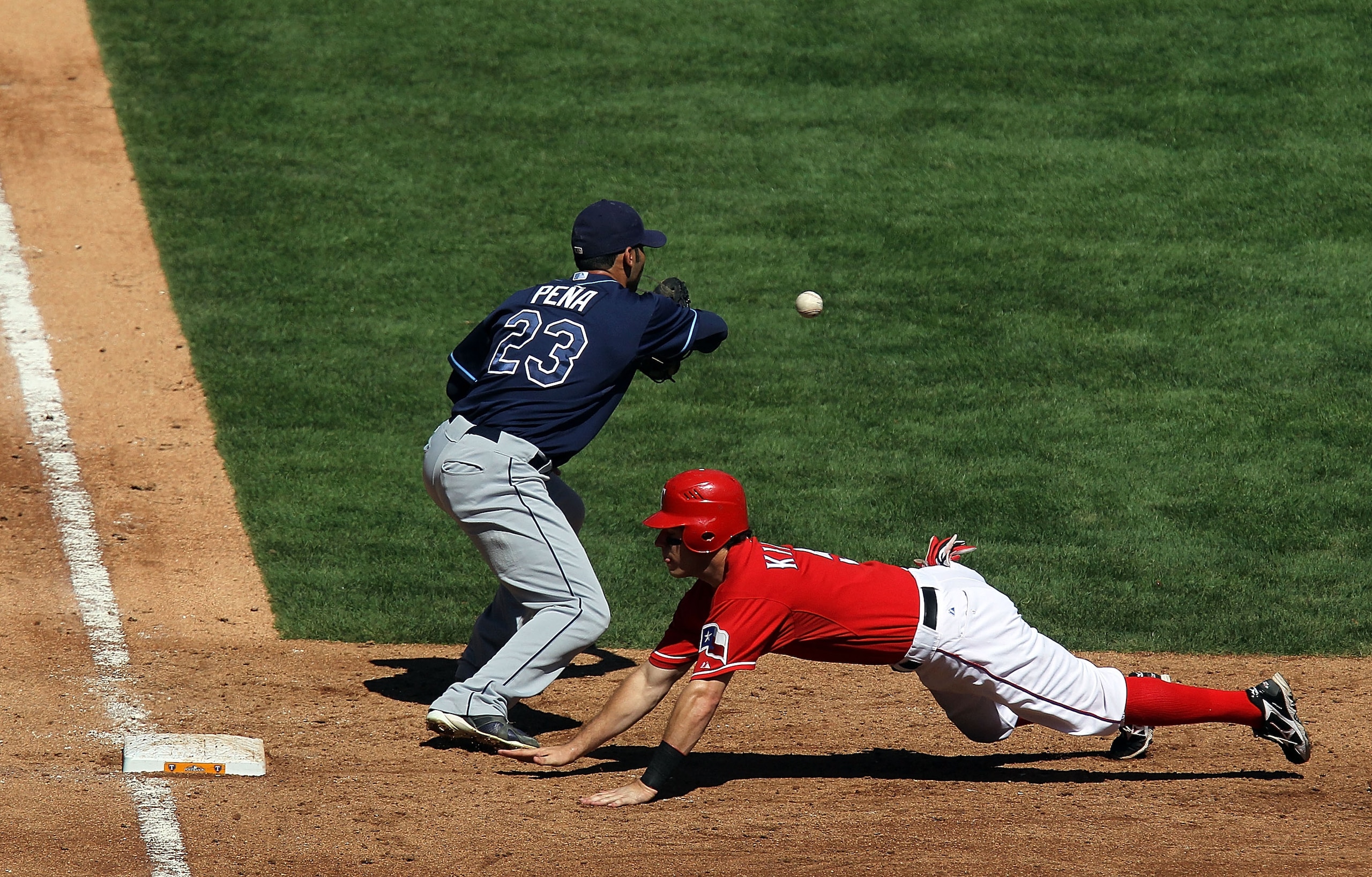 ARLINGTON, TX - OCTOBER 10:  Ian Kinsler #5 of the Texas Rangers dives back to first against Carlos Pena #23 of the Tampa Bay Rays during game 4 of the ALDS at Rangers Ballpark in Arlington on October 10, 2010 in Arlington, Texas.  (Photo by Ronald Martin