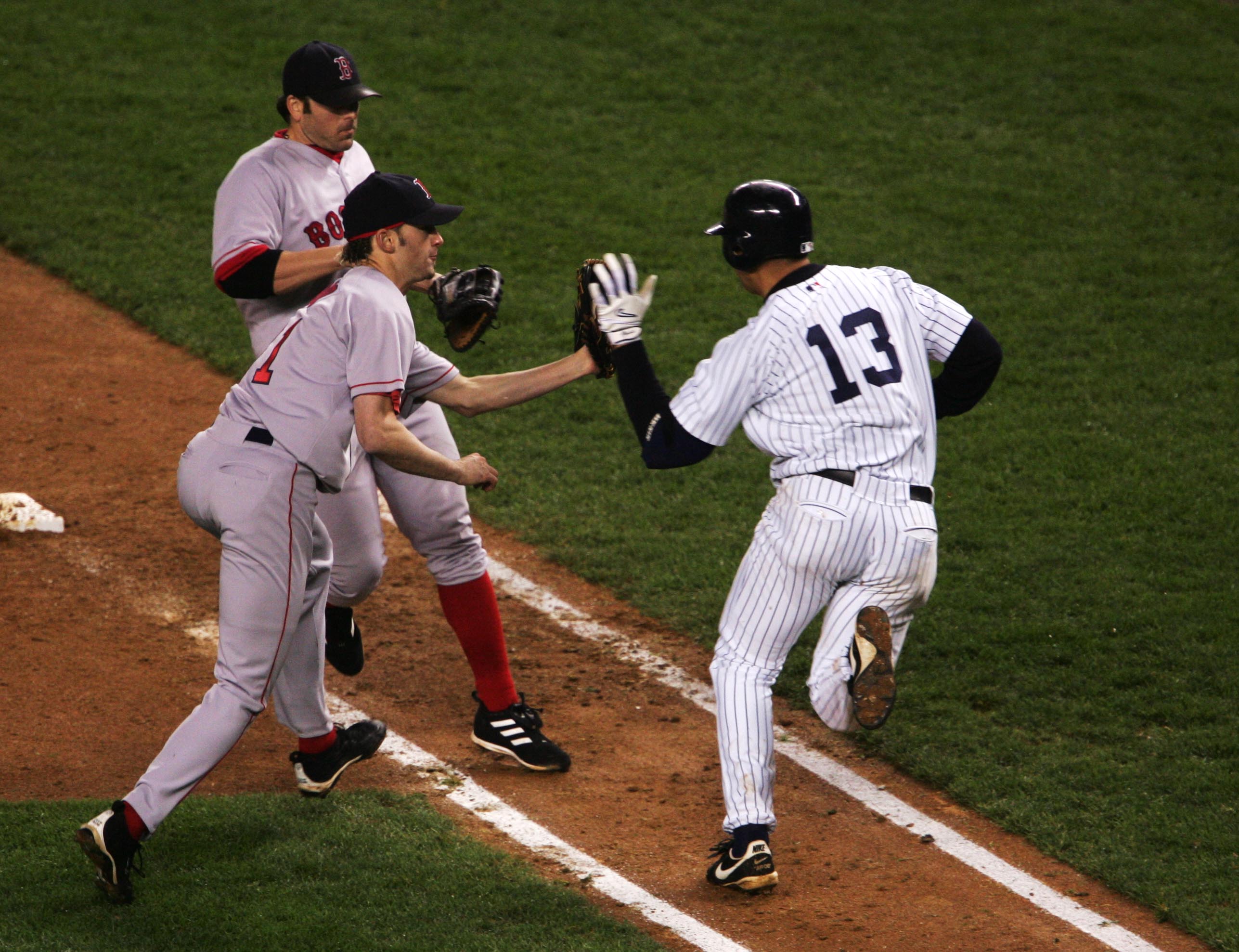 NEW YORK - OCTOBER 19:  Pitcher Bronson Arroyo #61 of the Boston Red Sox has the ball knocked out of his glove by batter Alex Rodriguez #13 of the New York Yankees on a tag-out at first base as first baseman Kevin Millar #15 looks on in the eighth inning