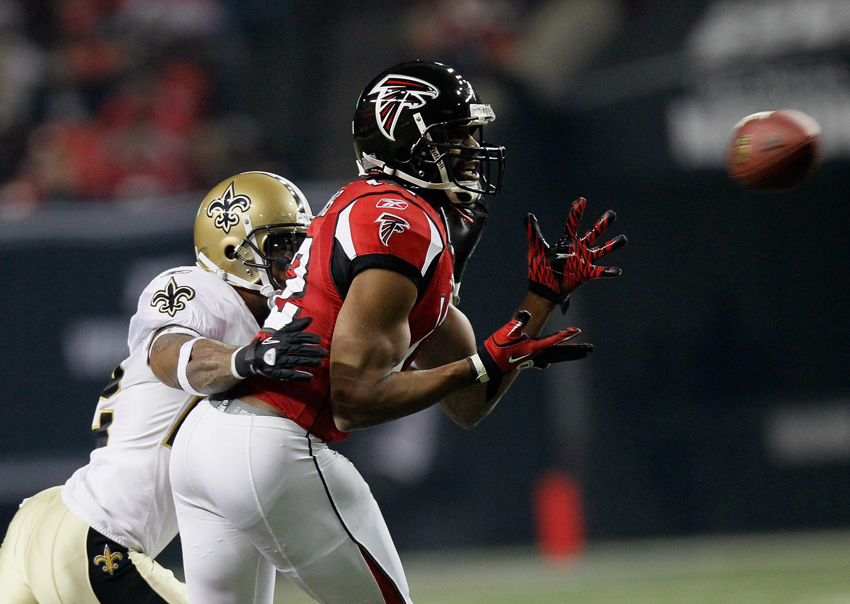 ATLANTA, GA - DECEMBER 27:  Michael Jenkins #12 of the Atlanta Falcons reaches for a pass in front of Tracy Porter #22 of the New Orleans Saints during their game at the Georgia Dome on December 27, 2010 in Atlanta, Georgia.  (Photo by Kevin C. Cox/Getty
