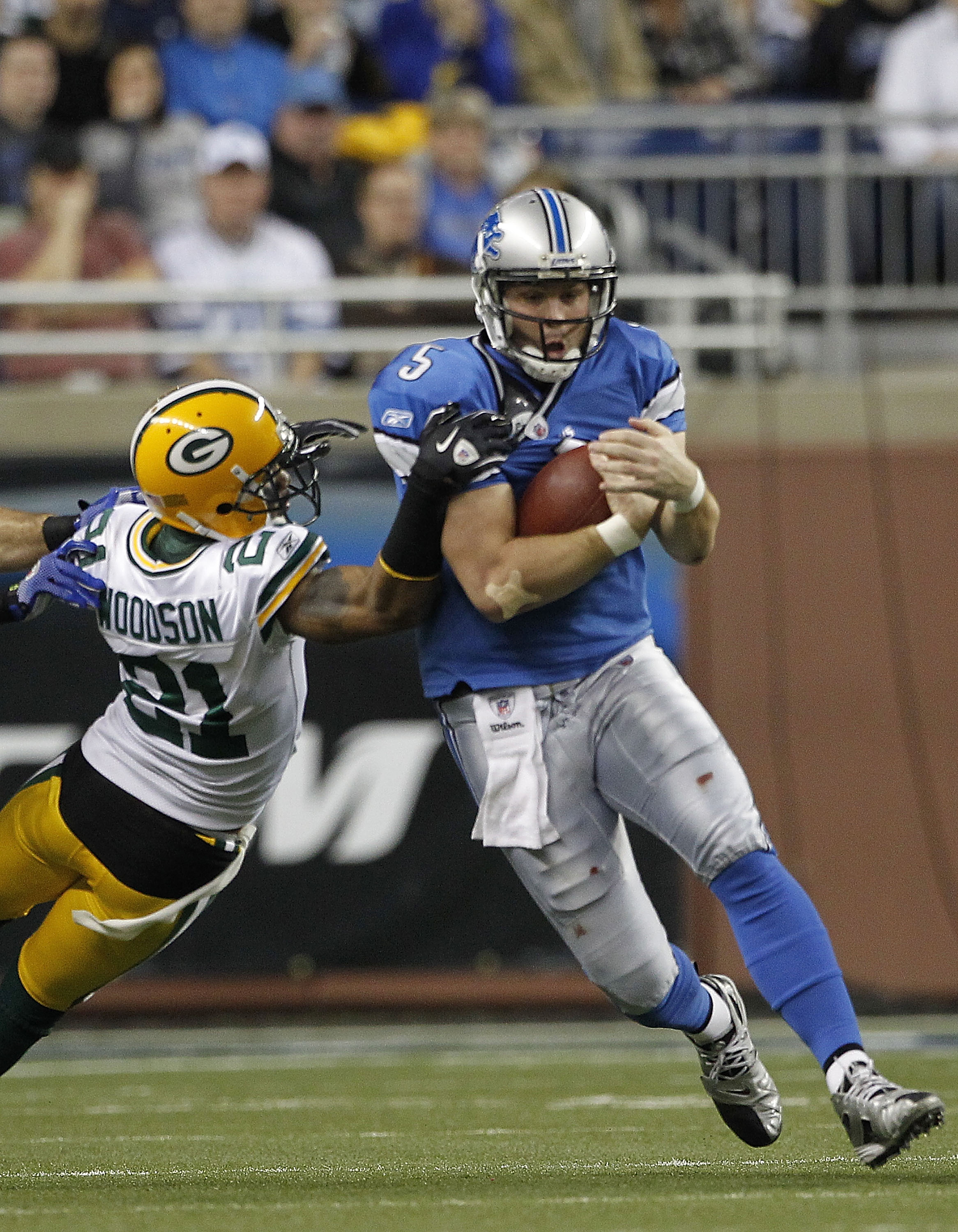 DETROIT - DECEMBER 12:  Drew Stanton #5 of the Detroit Lions runs for a first down as Charles Woodson #21 of the Green Bay Packers attempts to make the stop during the game at Ford Field on December 12, 2010 in Detroit, Michigan. The Lions defeated the Pa