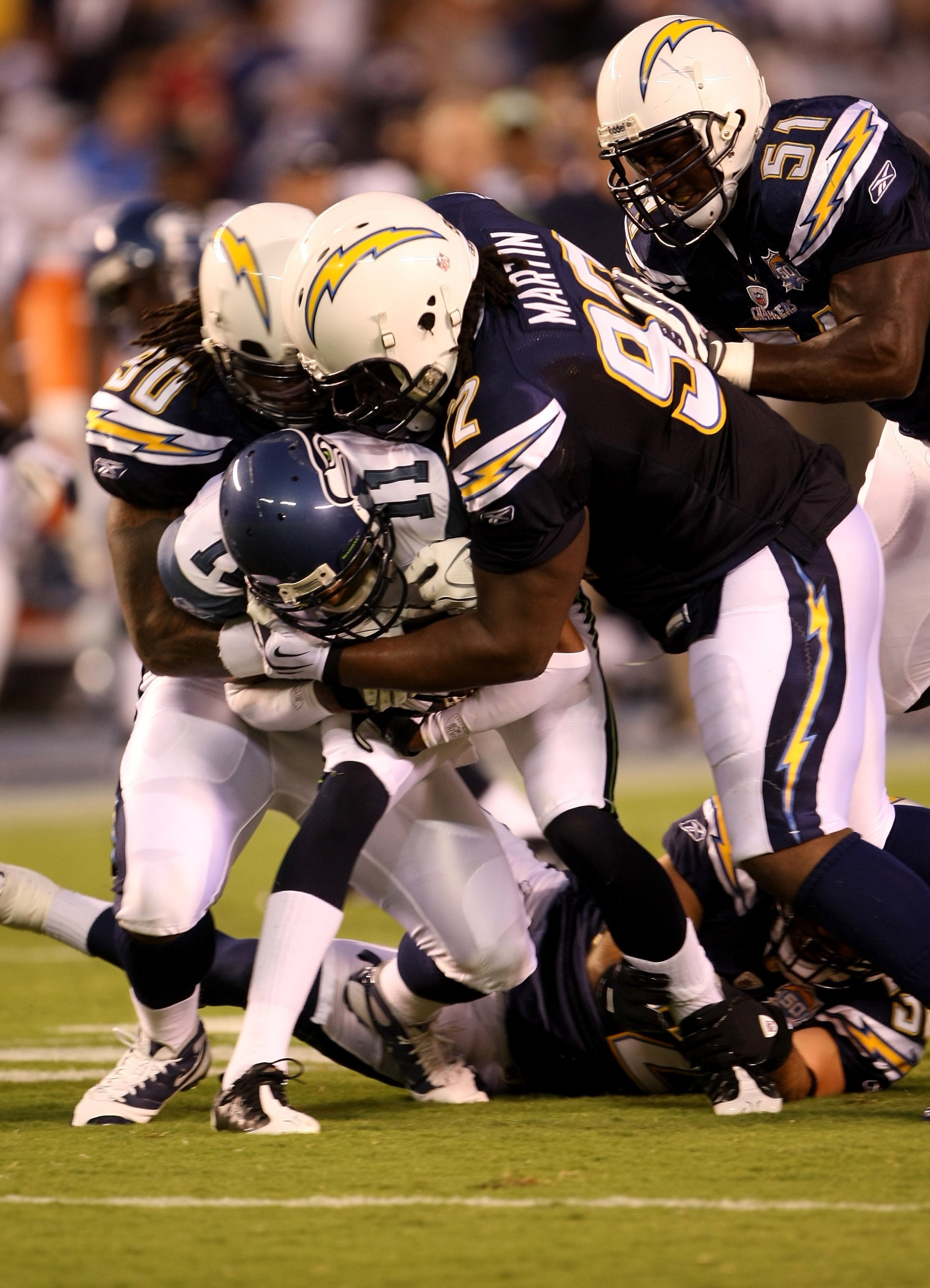 SAN DIEGO - AUGUST 15:  Linebacker Antwan Applewhite #90 and defensive end Vaughn Martin #92of the San Diego Chargers tackle receiver Deon Butler #11 of the Seattle Seahawks on August 15, 2009 at Qualcomm Stadium in San Diego, California.  (Photo by Steph