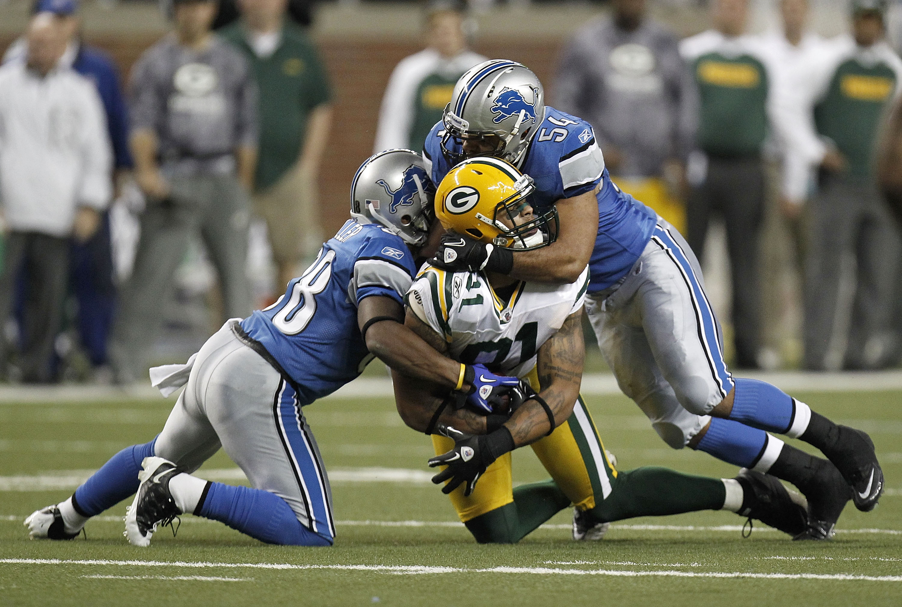 DETROIT, MI - DECEMBER 12: Andrew Quarless #81 of the Green Bay Packers is tackled by DeAndre Levy #54 and Prince Miller #38 of the Detroit Lions on December 12, 2010 at Ford Field in Detroit, Michigan. Detroit won the game 7-3. (Photo by Gregory Shamus/G