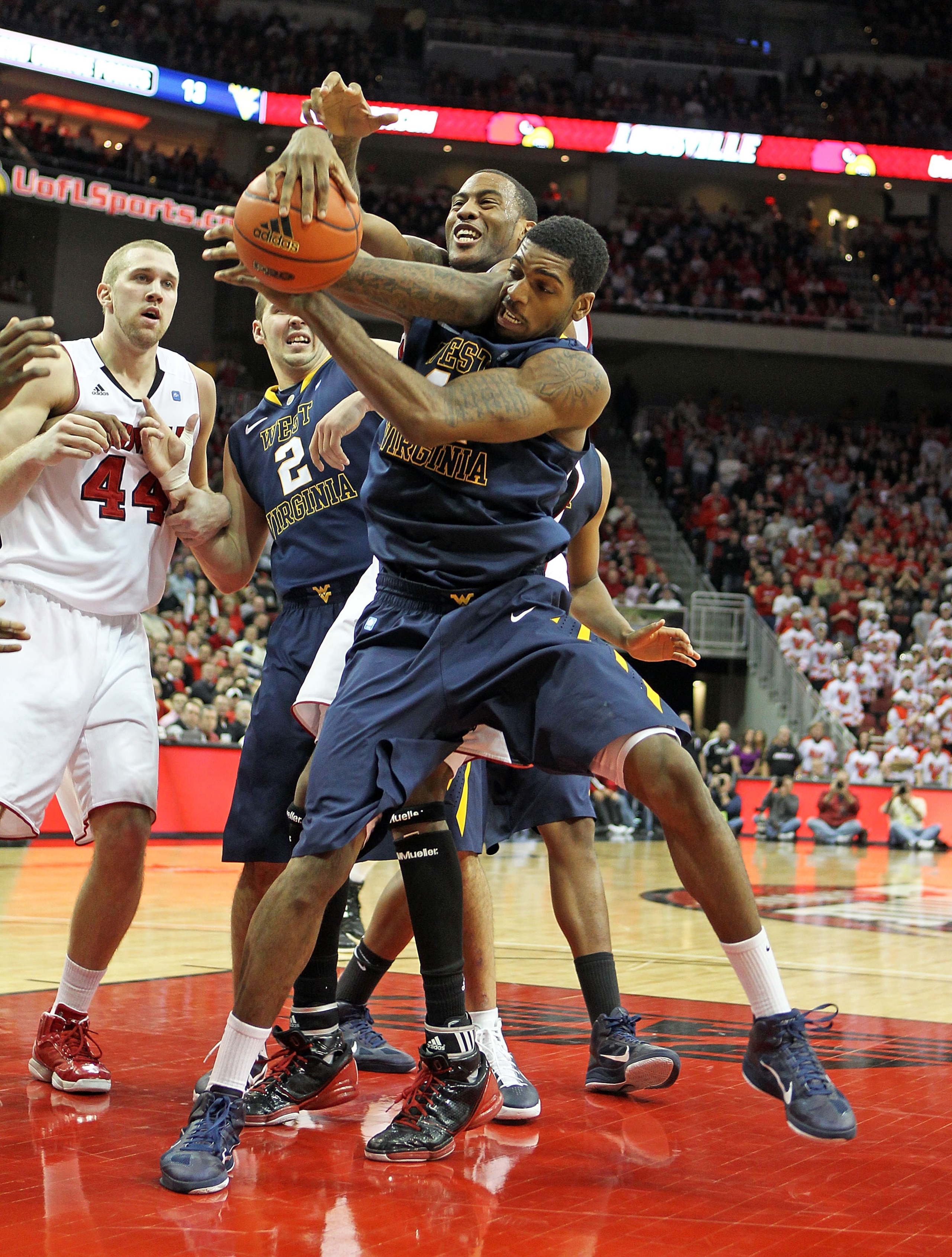 LOUISVILLE, KY - JANUARY 26: John Flowers #41 of the West Virginia Mountaineers grabs the ball while defended by Terrence Jennings #23 of the Louisville Cardinals during the Big East Conference game at the KFC Yum! Center on January 26, 2011 in Louisvill LOUISVILLE, KY - JANUARY 26: John Flowers #41 of the West Virginia Mountaineers grabs the ball while defended by Terrence Jennings #23 of the Louisville Cardinals during the Big East Conference game at the KFC Yum! Center on January 26, 2011 in Louisvill