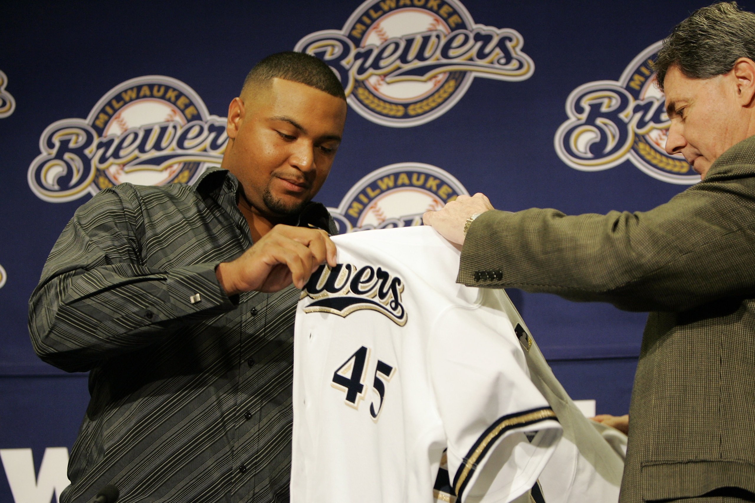 MILWAUKEE - JANUARY 10:  General manager Doug Melvin (R)  introduces Carlos Lee as #45 of the Milwaukee Brewer as he hands him his jersey January 10, 2005 at Miller Park in Milwaukee, Wisconsin.   (Photo by Brian Bahr/Getty Images)