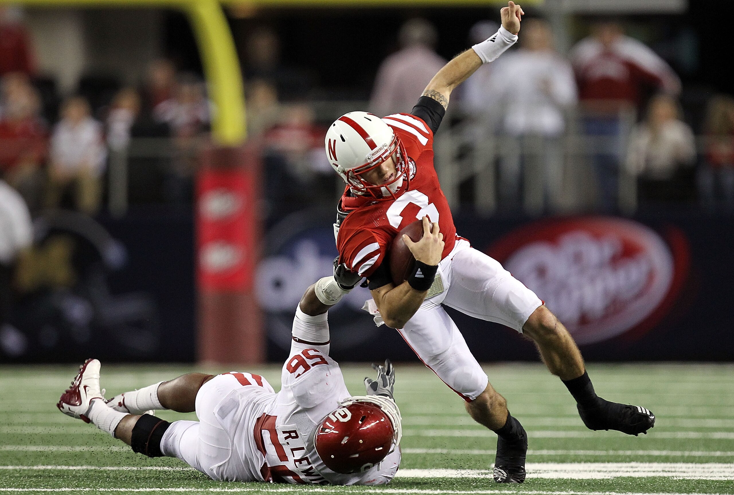 ARLINGTON, TX - DECEMBER 04: Quarterback Taylor Martinez #3 of the Nebraska Cornhuskers is tackled by Ronnell Lewis #56 of the Oklahoma Sooners during the Big 12 Championship at Cowboys Stadium on December 4, 2010 in Arlington, Texas. (Photo by Ronald M ARLINGTON, TX - DECEMBER 04: Quarterback Taylor Martinez #3 of the Nebraska Cornhuskers is tackled by Ronnell Lewis #56 of the Oklahoma Sooners during the Big 12 Championship at Cowboys Stadium on December 4, 2010 in Arlington, Texas. (Photo by Ronald M