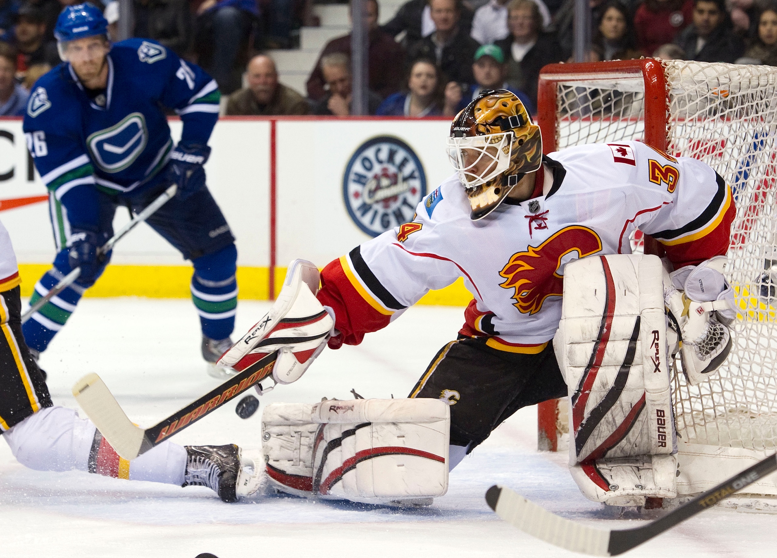 VANCOUVER, CANADA - FEBRUARY 12: Goalie Miikka Kiprusoff #36 of the Calgary Flames breaks up a pass intended for Mikael Samuelsson #26 of the Vancouver Canucks during the second period in NHL action on February 12, 2011 at Rogers Arena in Vancouver, Briti