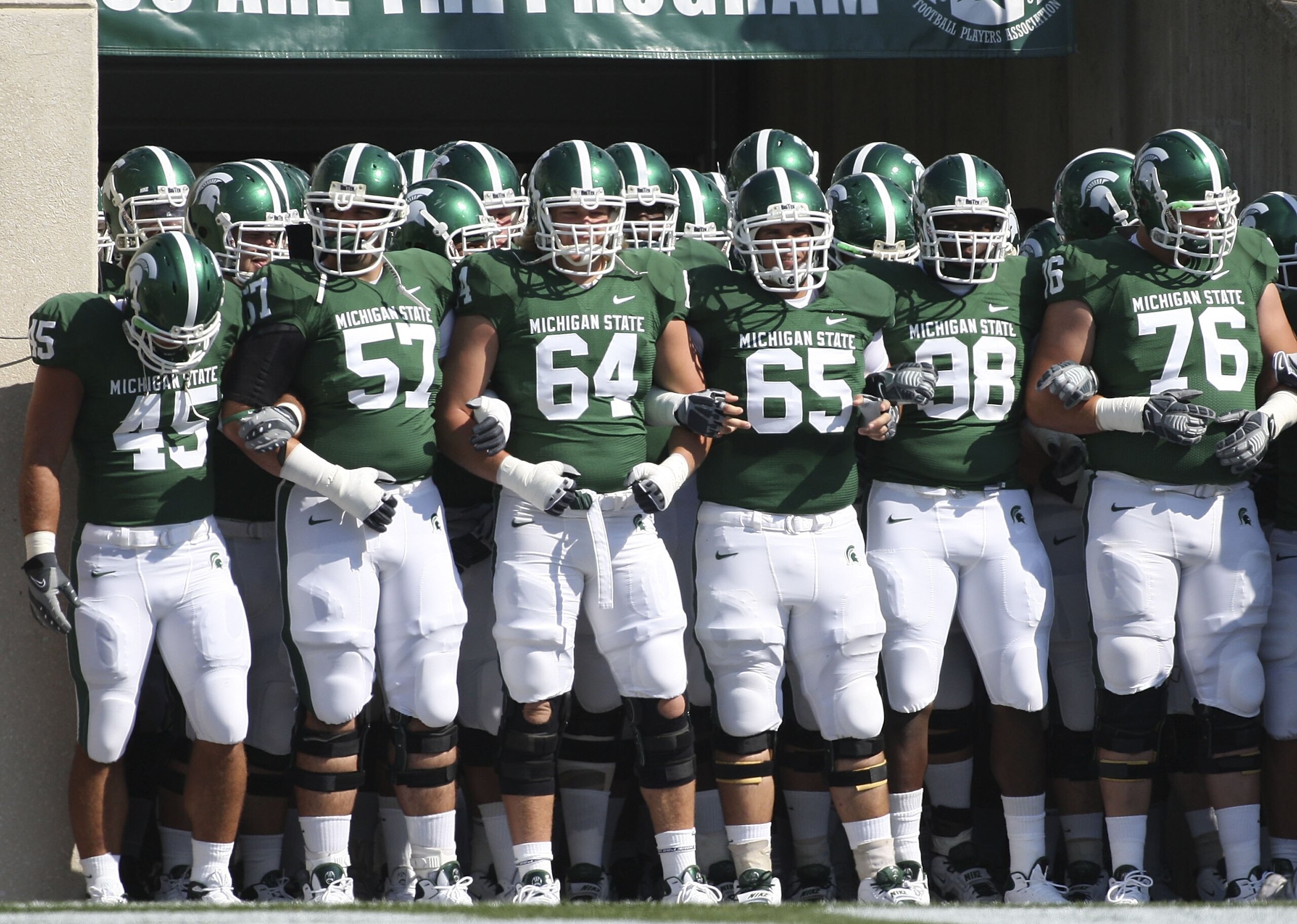 EAST LANSING, MI - SEPTEMBER 05: Brendon Moss #64 and Joe Nitchman #65 lead the Michigan State Spartans onto the field prior to the start of the game against the Montana State Bobcats on September 5, 2009 at Spartan Stadium in East Lansing, Michigan.  (Ph