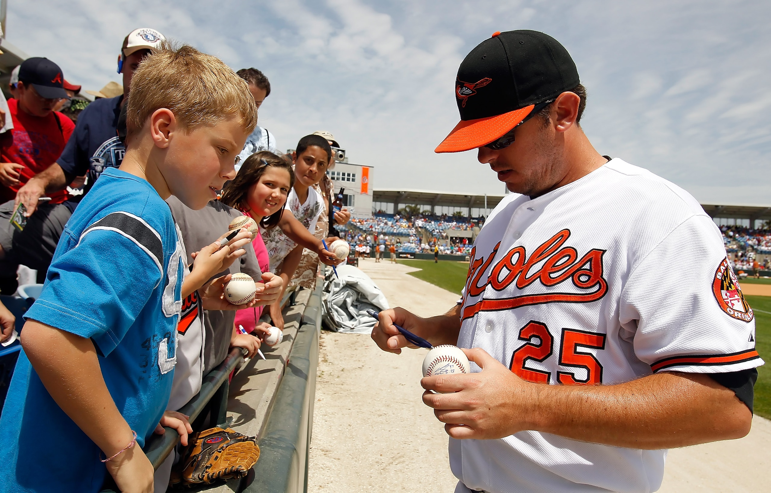 SARASOTA, FL - APRIL 03:  Infielder Garrett Atkins #25 of the Baltimore Orioles signs autographs prior to the start of the Grapefruit League Spring Training Game against the New York Mets at Ed Smith Stadium on April 3, 2010 in Sarasota, Florida.  (Photo