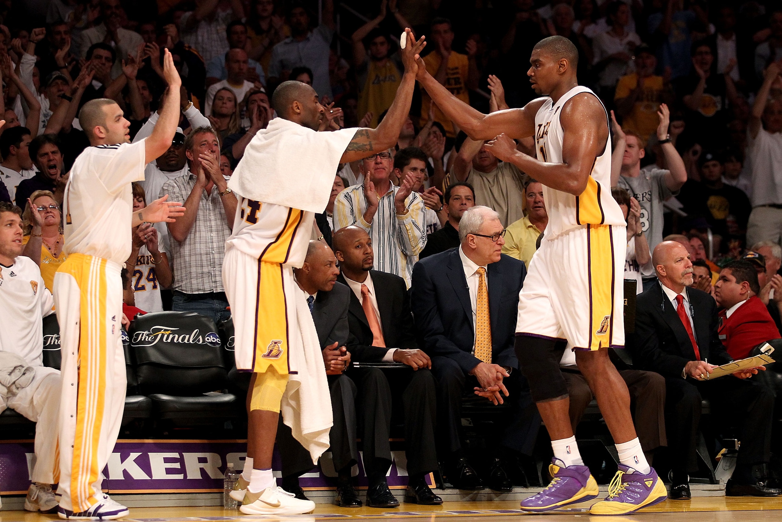 LOS ANGELES, CA - JUNE 06:  Andrew Bynum #17 returns to the bench and is greeted by teammates Kobe Bryant #24 and Jordan Farmar #1 of the Los Angeles Lakers in Game Two of the 2010 NBA Finals against the Boston Celtics at Staples Center on June 6, 2010 in