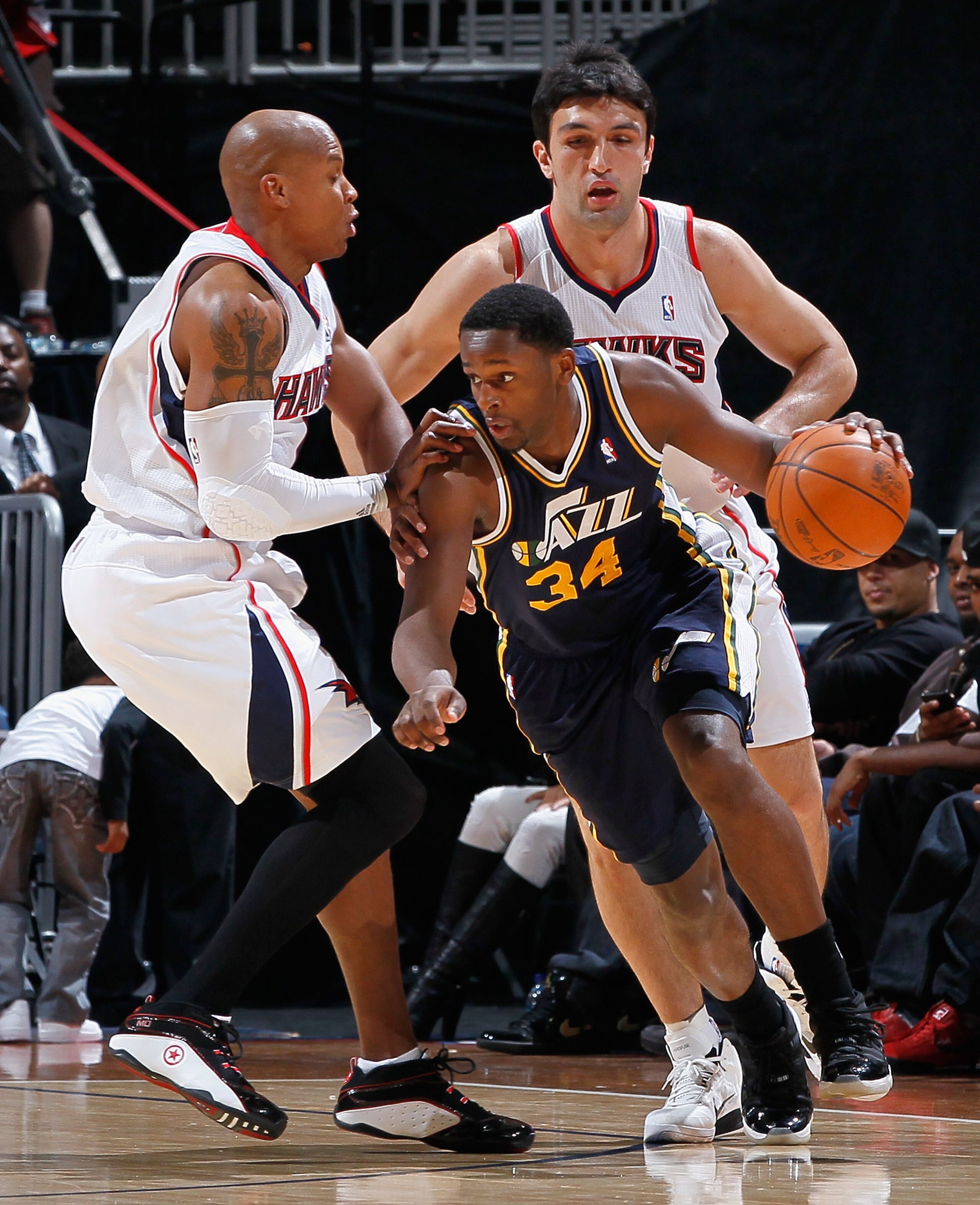 ATLANTA - NOVEMBER 12:  C.J. Miles #34 of the Utah Jazz drives around Maurice Evans #1 and Zaza Pachulia #27 of the Atlanta Hawks at Philips Arena on November 12, 2010 in Atlanta, Georgia.  NOTE TO USER: User expressly acknowledges and agrees that, by dow
