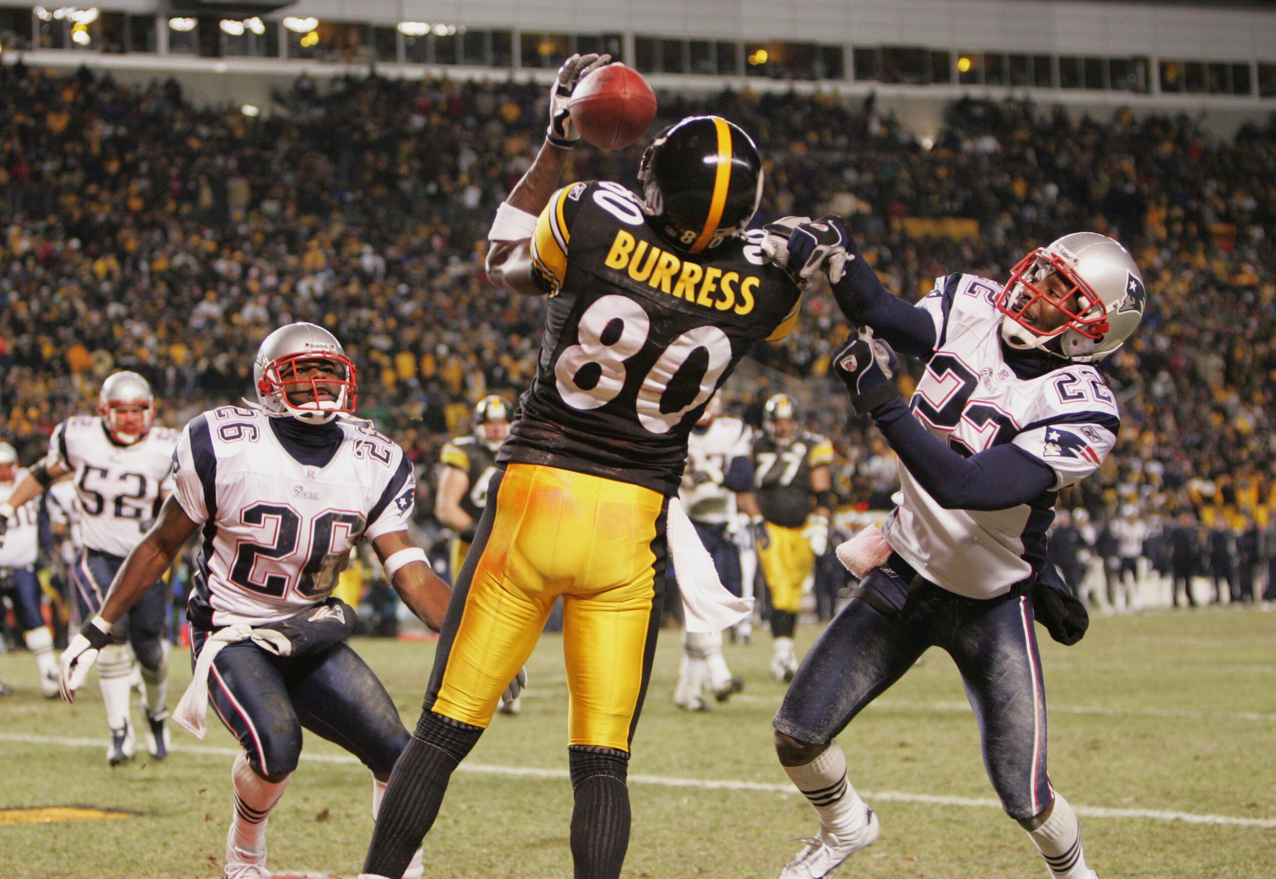 PITTSBURGH - JANUARY 23:   Wide receiver Plaxico Burress #80 of the Pittsburgh Steelers can't hang on to a pass while being defended by defensive backs Eugene Wilson #26 and Asante Samuel #22 of the New England Patriots in the AFC championship game at Hei