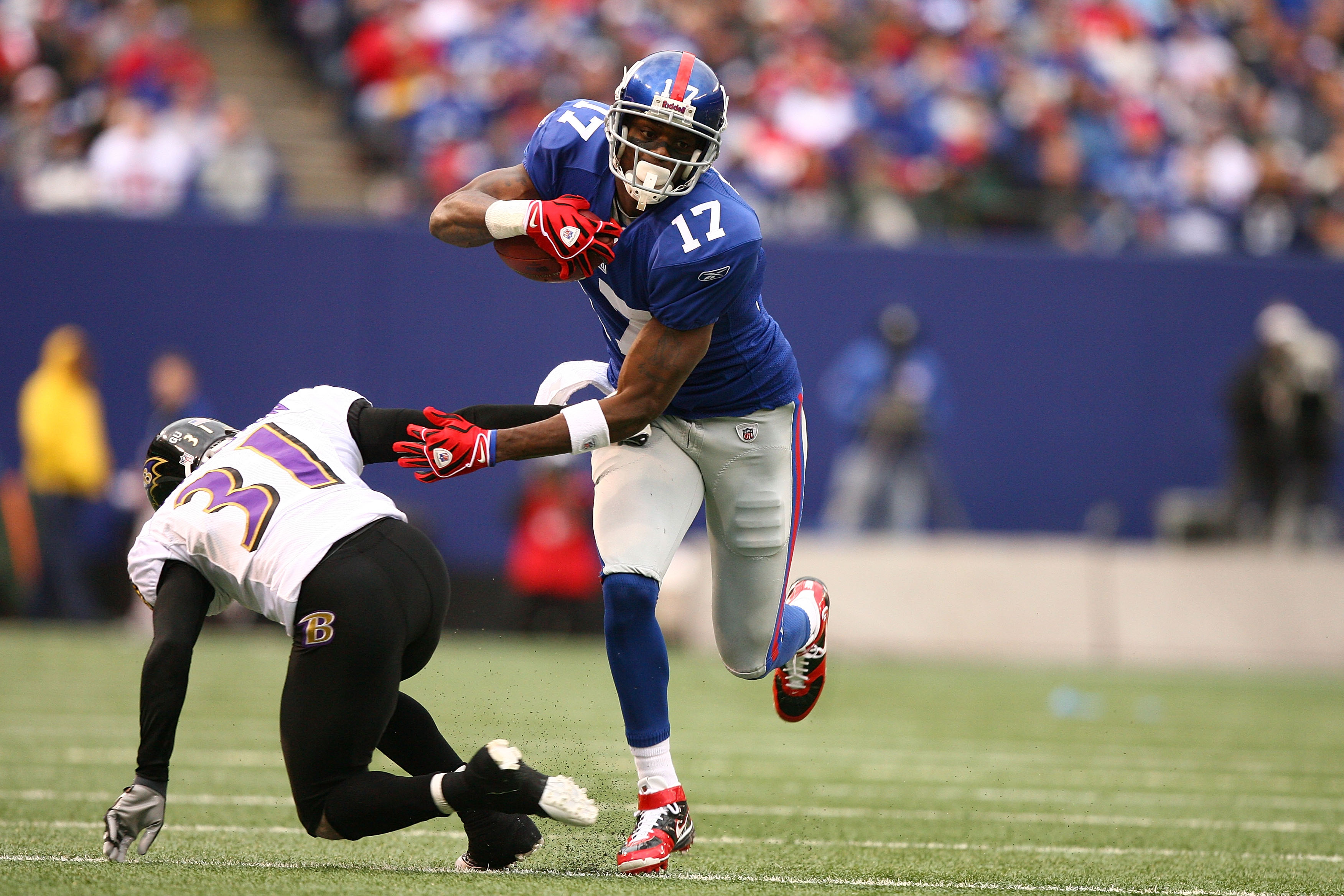 EAST RUTHERFORD, NJ - NOVEMBER 16:  Plaxico Burress #17 of the New York Giants eludes the tackle of Fabian Washington #31 of the Baltimore Ravens during their game on November 16, 2008 at Giants Stadium in East Rutherford, New Jersey.  (Photo by Al Bello/