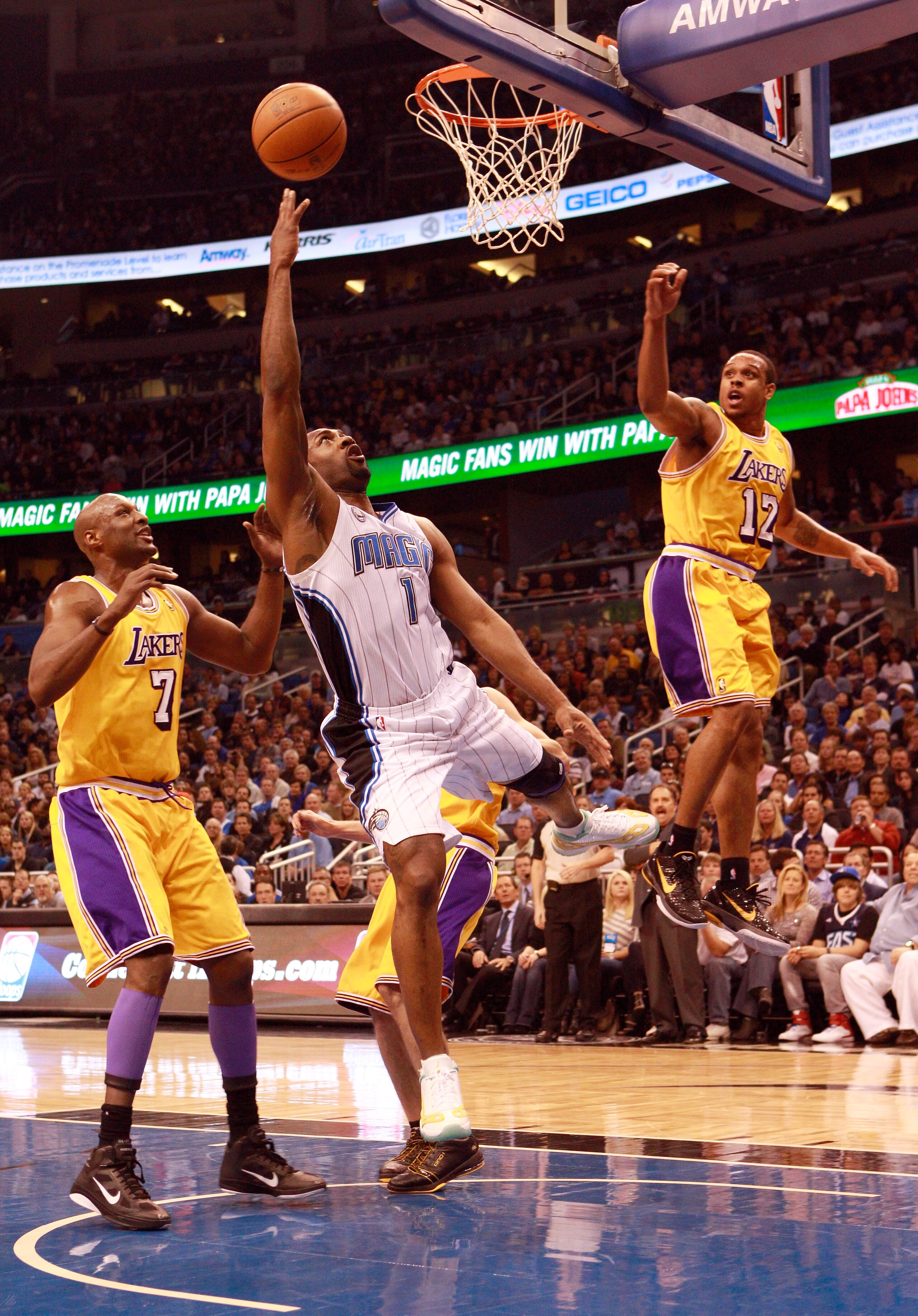 ORLANDO, FL - FEBRUARY 13:  Gilbert Arenas #1 of the Orlando Magic attempts a shot against Lamar Odom #7 and Shannon Brown #12 of the Los Angeles Lakers during the game at Amway Arena on February 13, 2011 in Orlando, Florida.  NOTE TO USER: User expressly