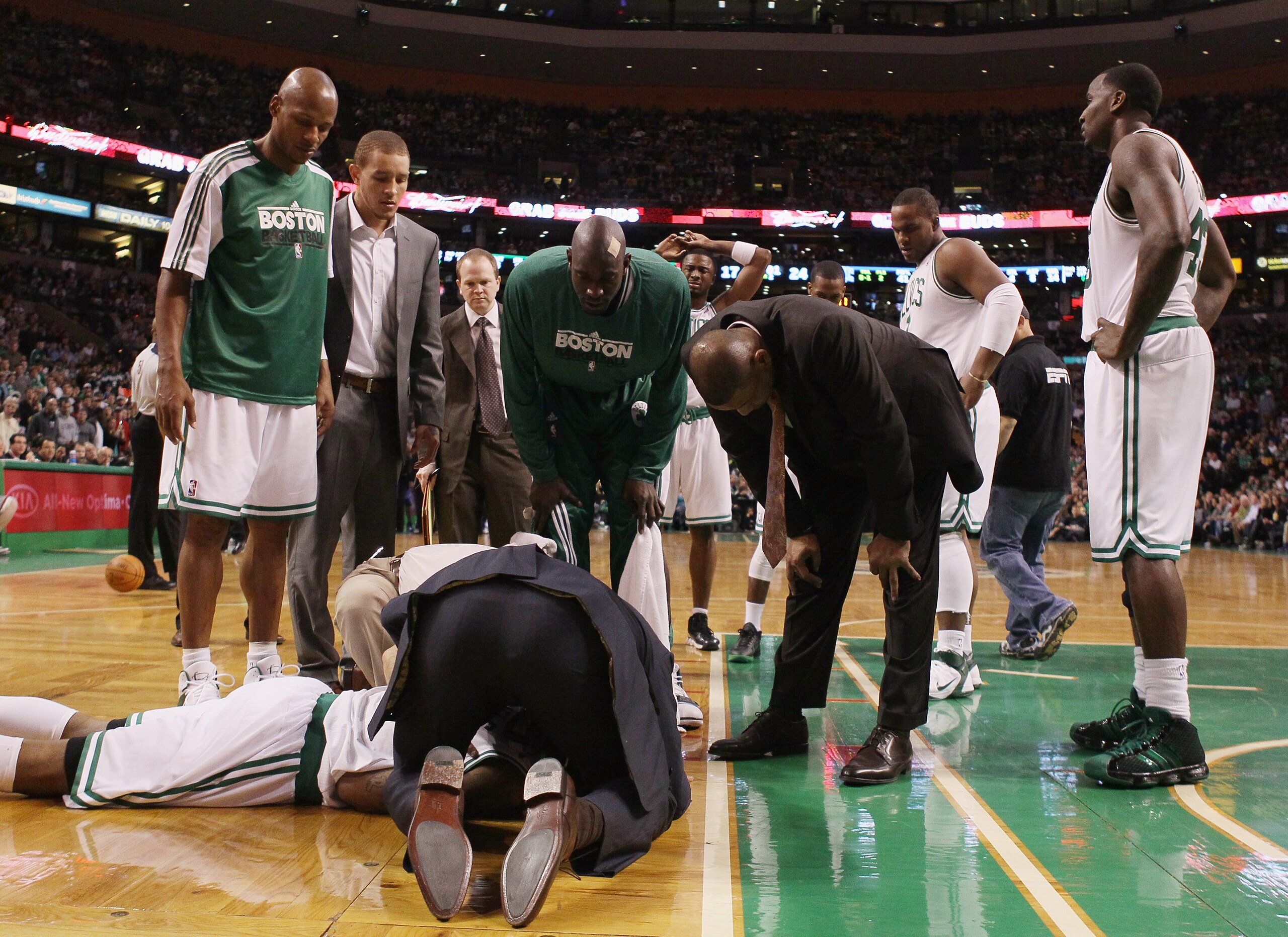 BOSTON, MA - FEBRUARY 06:  Teammates gather around Marquis Daniels #8 the Boston as he is looked after by medical personnel after Daniels collided with Gilbert Arenas of the Orlando Magic on February 6, 2011 at the TD Garden in Boston, Massachusetts.  Dan