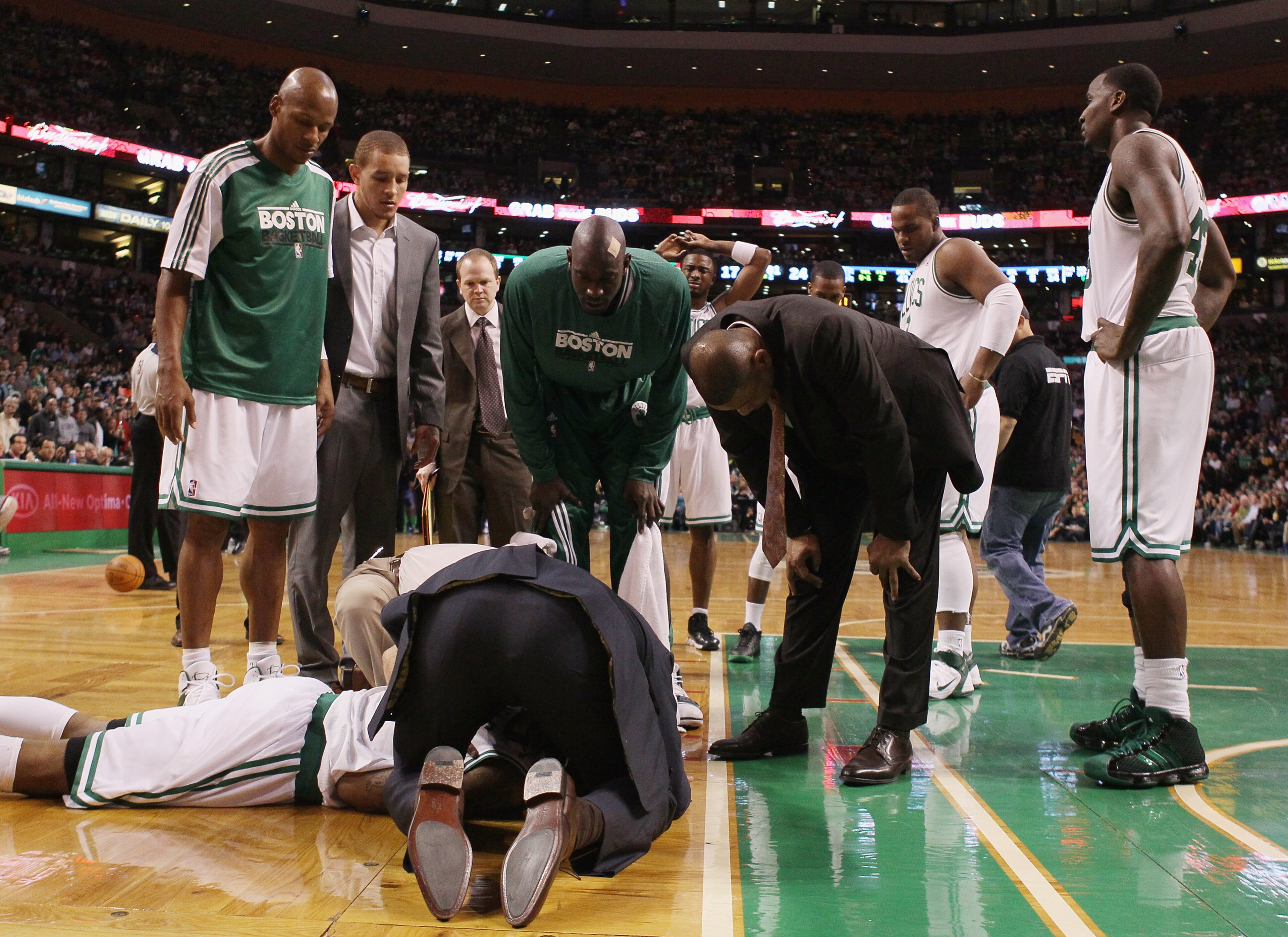 BOSTON, MA - FEBRUARY 06:  Teammates gather around Marquis Daniels #8 the Boston as he is looked after by medical personnel after Daniels collided with Gilbert Arenas of the Orlando Magic on February 6, 2011 at the TD Garden in Boston, Massachusetts.  Dan
