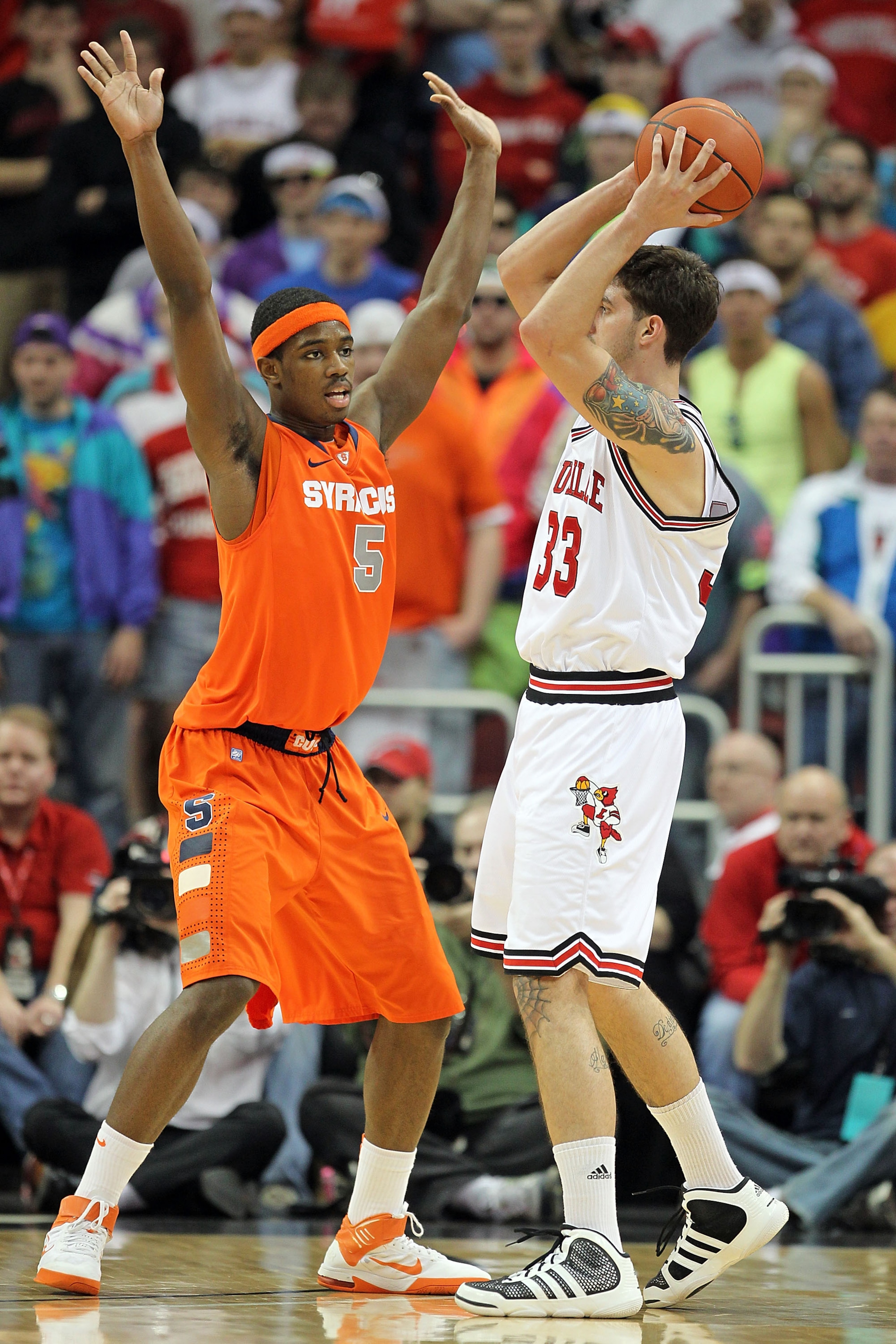 LOUISVILLE, KY - FEBRUARY 12: C.J. Fair #5 of the Syracuse Orange defends Mike Marra #33 of the Louisville Cardinals during the Big East Conference game at the KFC Yum! Center on February 12, 2011 in Louisville, Kentucky.  Louisville won 73-69.  (Photo by