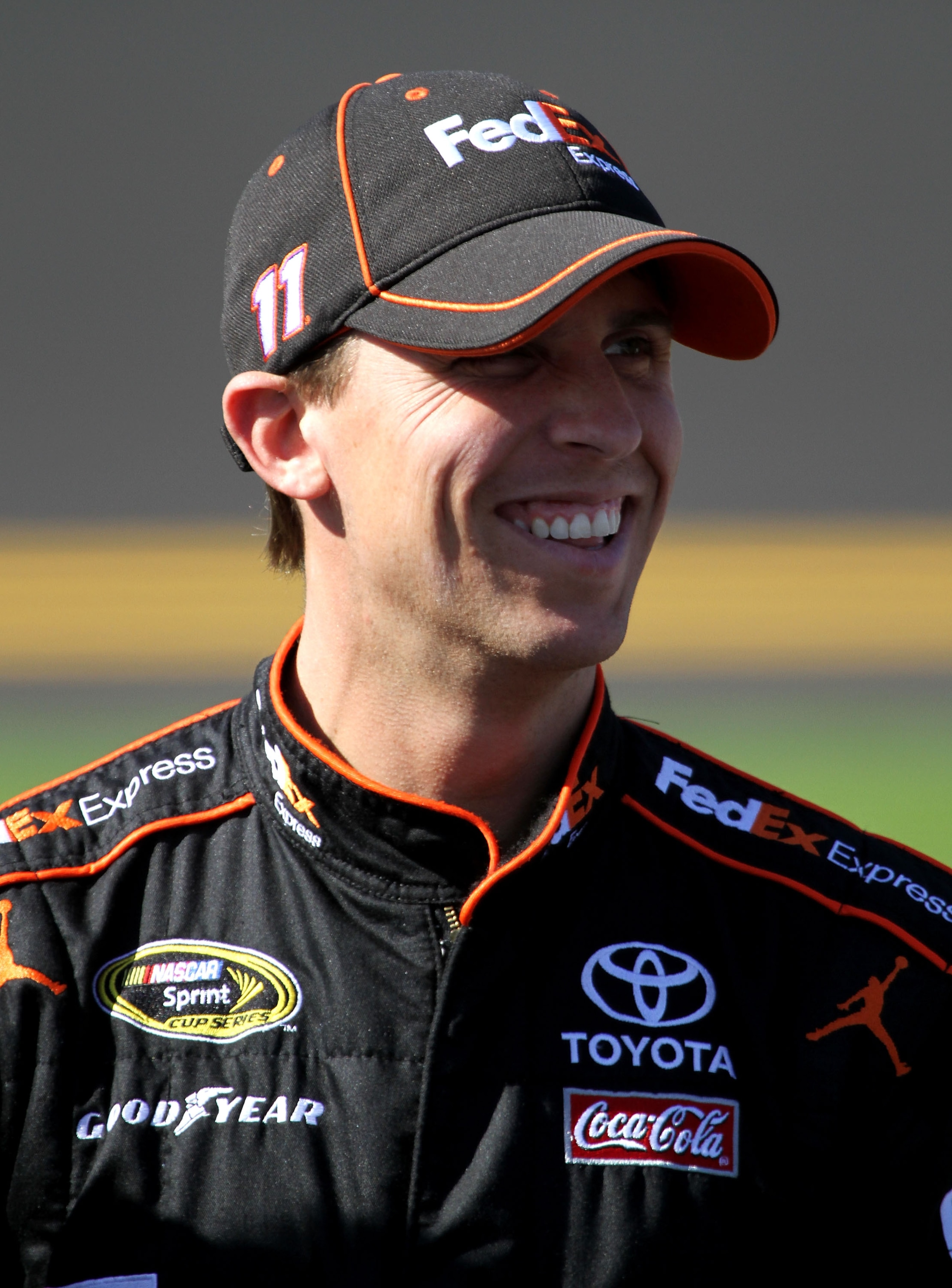 DAYTONA BEACH, FL - FEBRUARY 13:  Denny Hamlin, driver of the #11 FedEx Toyota, stands on the grid during qualifying for the NASCAR Sprint Cup Series Daytona 500 at Daytona International Speedway on February 13, 2011 in Daytona Beach, Florida.  (Photo by