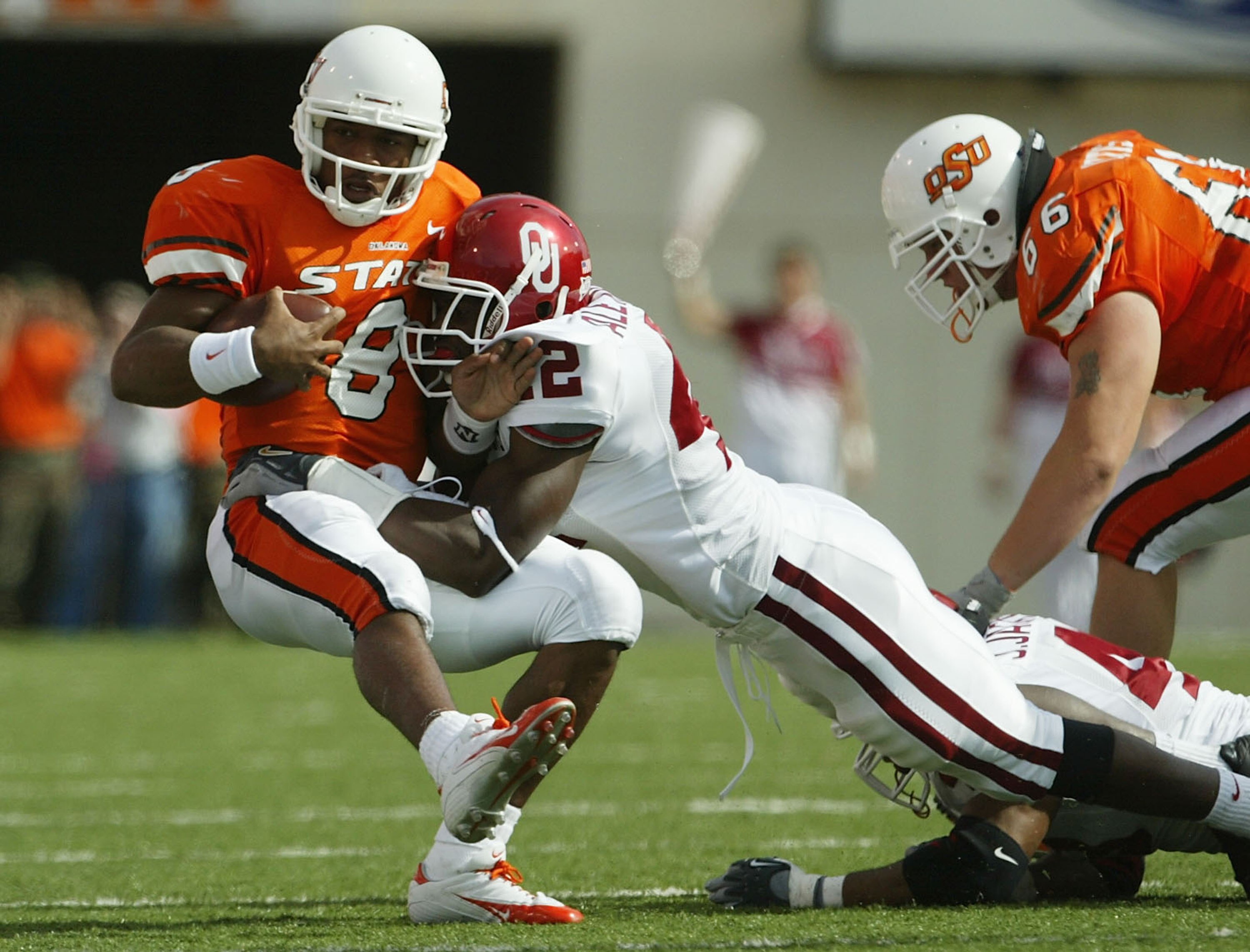 STILLWATER, OK - OCTOBER 30:  Quarterback Donovan Woods #8 of Oklahoma State is tackled by Rufus Alexander #42 of Oklahoma at Boone Pickens Stadium on October 30, 2004 in Stillwater, Oklahoma. Oklahoma defeated Oklahoma State 38-35. (Photo by Jeff Gross/G