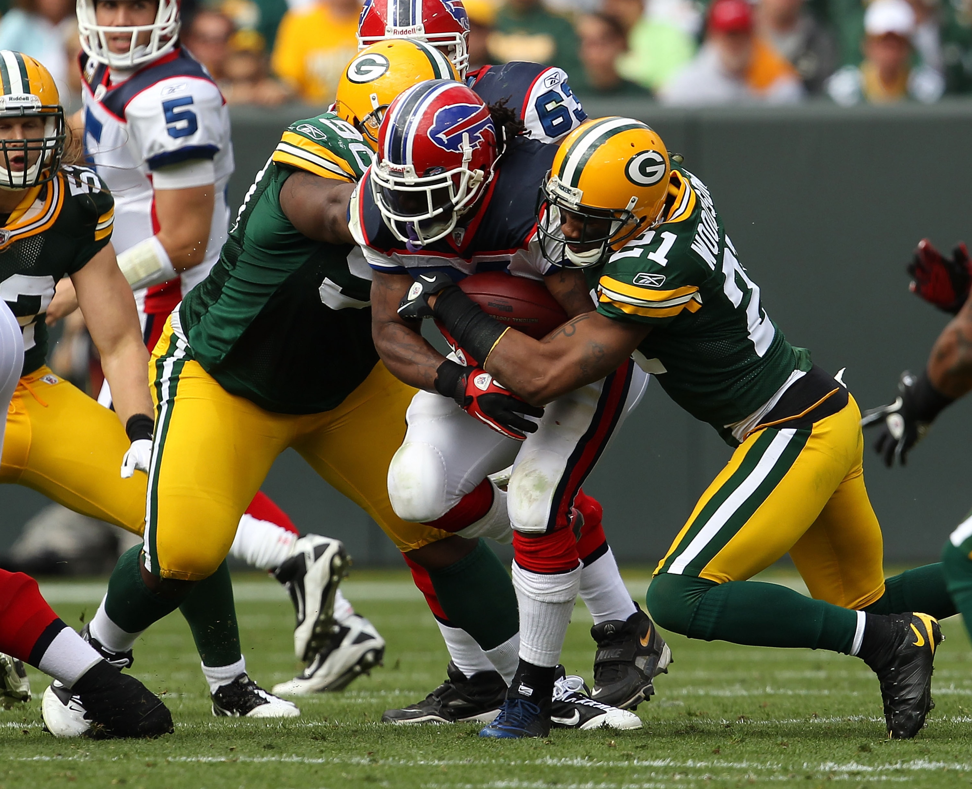GREEN BAY, WI - SEPTEMBER 19: Marshawn Lynch #23 of the Buffalo Bills is tackled by Charles Woodson #21 and B.J. Raji #90 of the Green Bay Packers at Lambeau Field on September 19, 2010 in Green Bay, Wisconsin. The Packers defeated the Bills 34-7. (Photo GREEN BAY, WI - SEPTEMBER 19: Marshawn Lynch #23 of the Buffalo Bills is tackled by Charles Woodson #21 and B.J. Raji #90 of the Green Bay Packers at Lambeau Field on September 19, 2010 in Green Bay, Wisconsin. The Packers defeated the Bills 34-7. (Photo