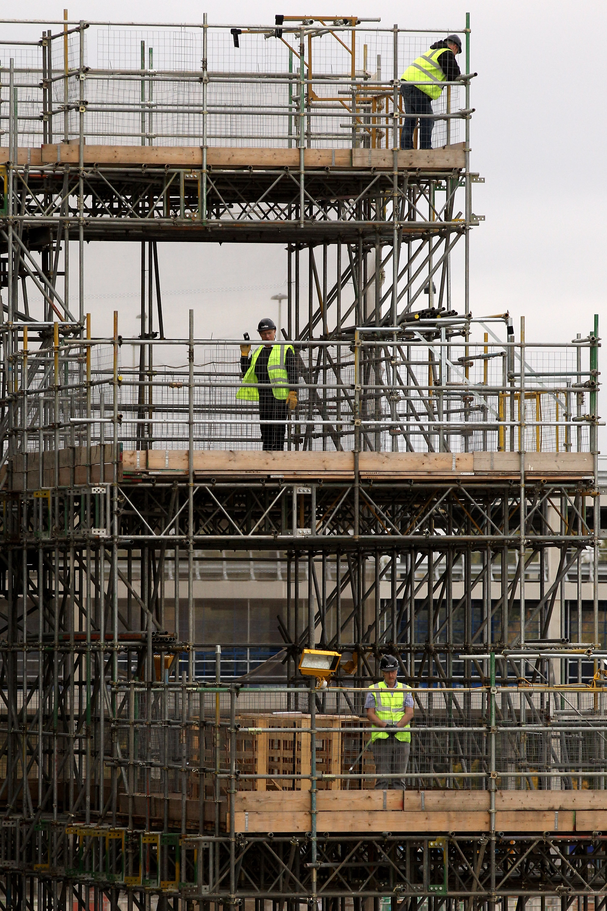 LONDON, ENGLAND - NOVEMBER 04:  Construction workers at the Olympic Park wait to see the Prime Minister David Cameron during his visit the site on November 4, 2010 in London, England. Mr Cameron today expressed his desire for the site of the London 2012 O