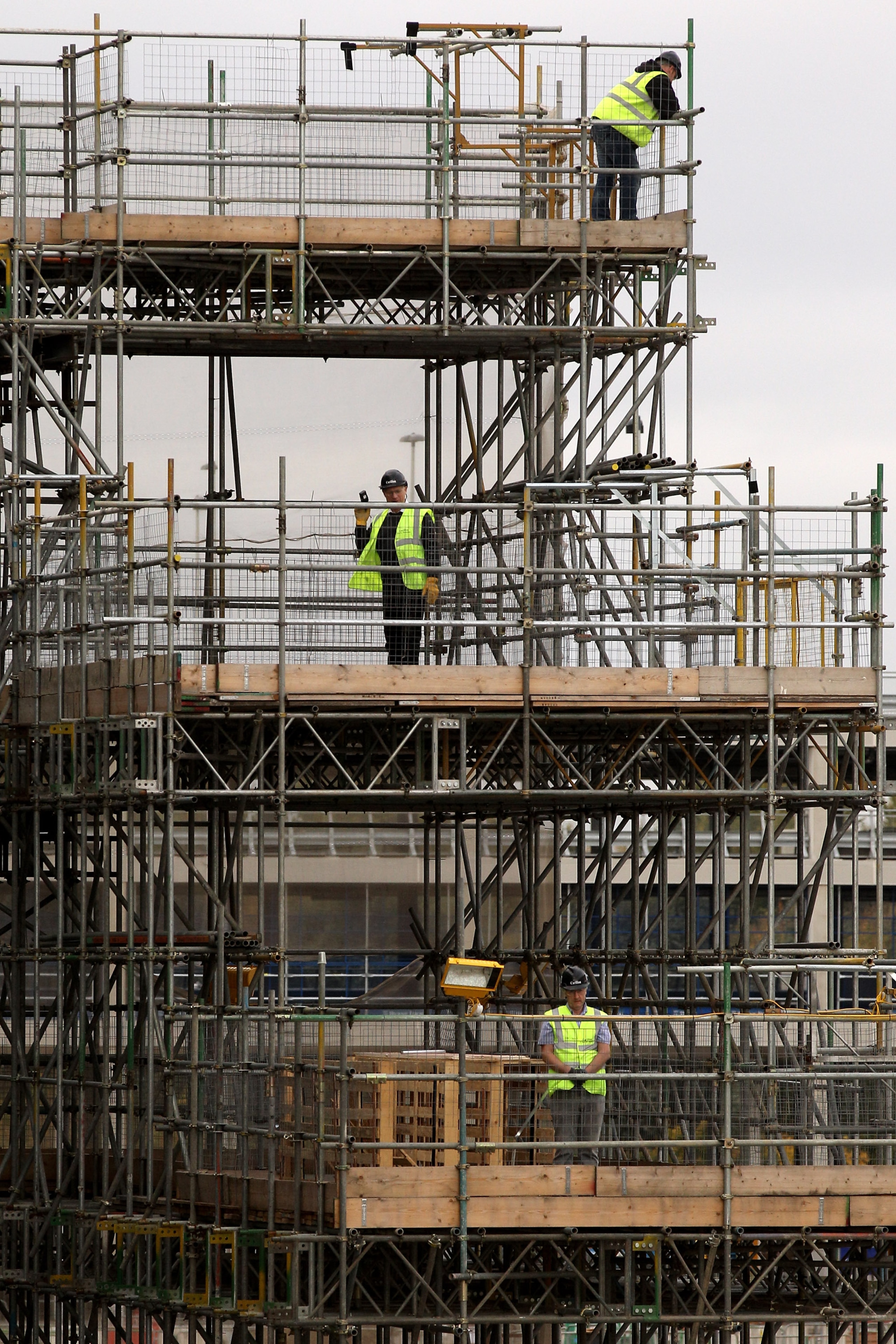LONDON, ENGLAND - NOVEMBER 04:  Construction workers at the Olympic Park wait to see the Prime Minister David Cameron during his visit the site on November 4, 2010 in London, England. Mr Cameron today expressed his desire for the site of the London 2012 O