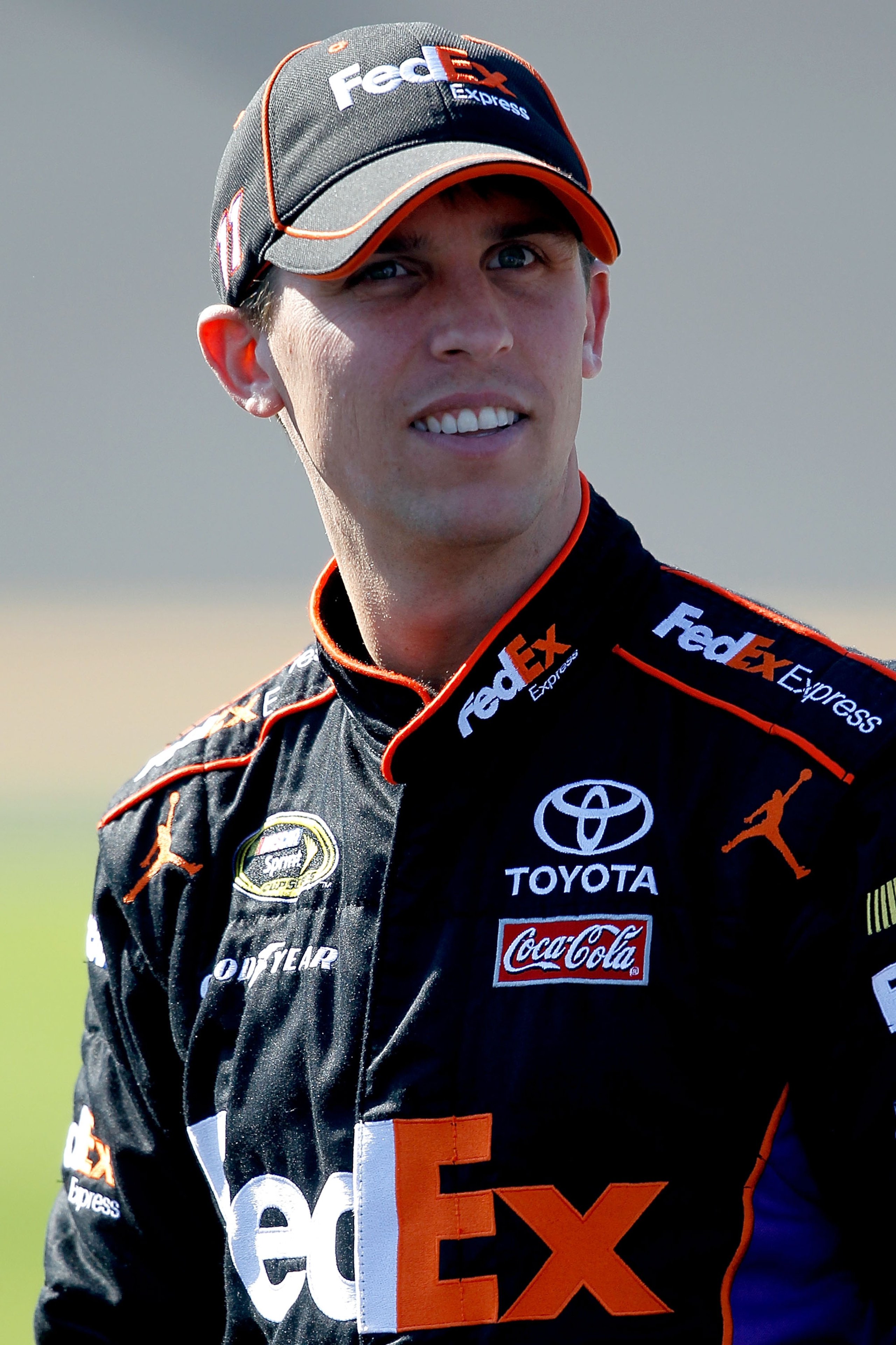 DAYTONA BEACH, FL - FEBRUARY 13:  Denny Hamlin, driver of the #11 FedEx Toyota, stands on the grid during qualifying for the NASCAR Sprint Cup Series Daytona 500 at Daytona International Speedway on February 13, 2011 in Daytona Beach, Florida.  (Photo by