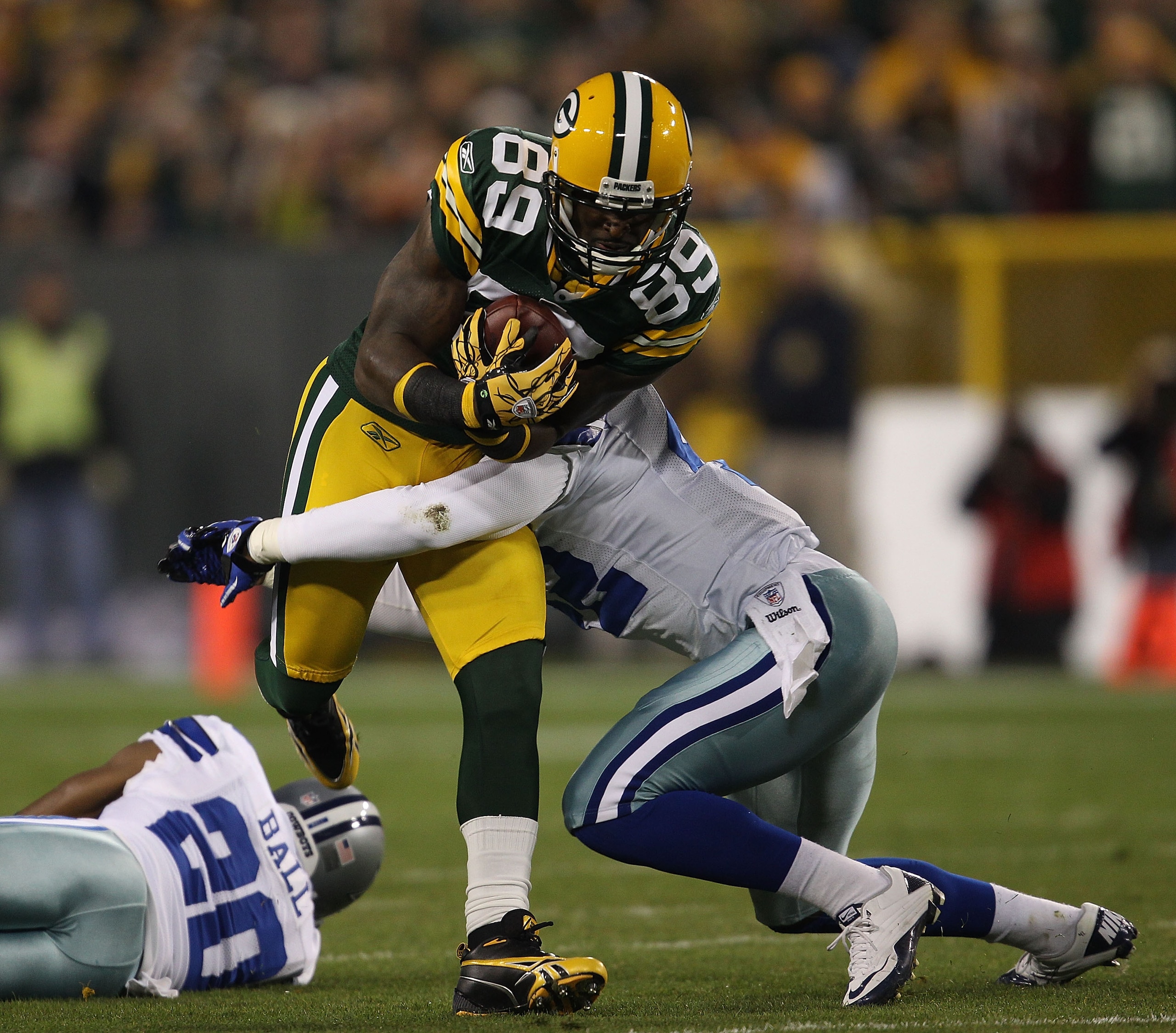 GREEN BAY, WI - NOVEMBER 07: James Jones #89 of the Green Bay Packers runs past Alan Ball #20 of the Dallas Cowboys as Barry Church #42 moves in for the tackle at Lambeau Field on November 7, 2010 in Green Bay, Wisconsin. The Packers defeated the Cowboys