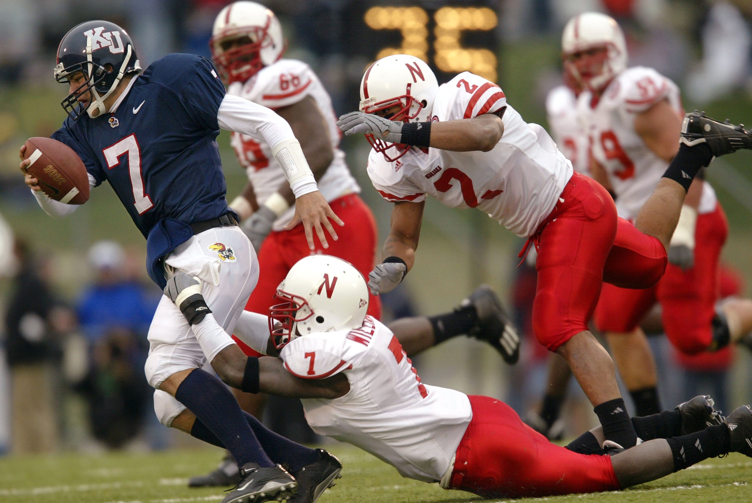 LAWRENCE, KS - NOVEMBER 8:  Demorrio Williams #7 of the Nebraska Cornhuskers brings down quarterback Adam Barmann #7 of the Kansas Jay Hawks behind the line of scrimmage as T.J. Hollowell #2 pursues in the first half November 8, 2003 at Memorial Stadium i